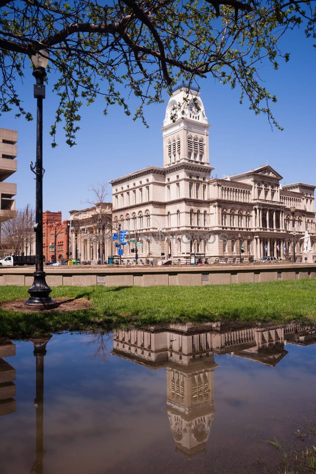 City Hall is reflected in water that has collected in the park across the street during recent flooding