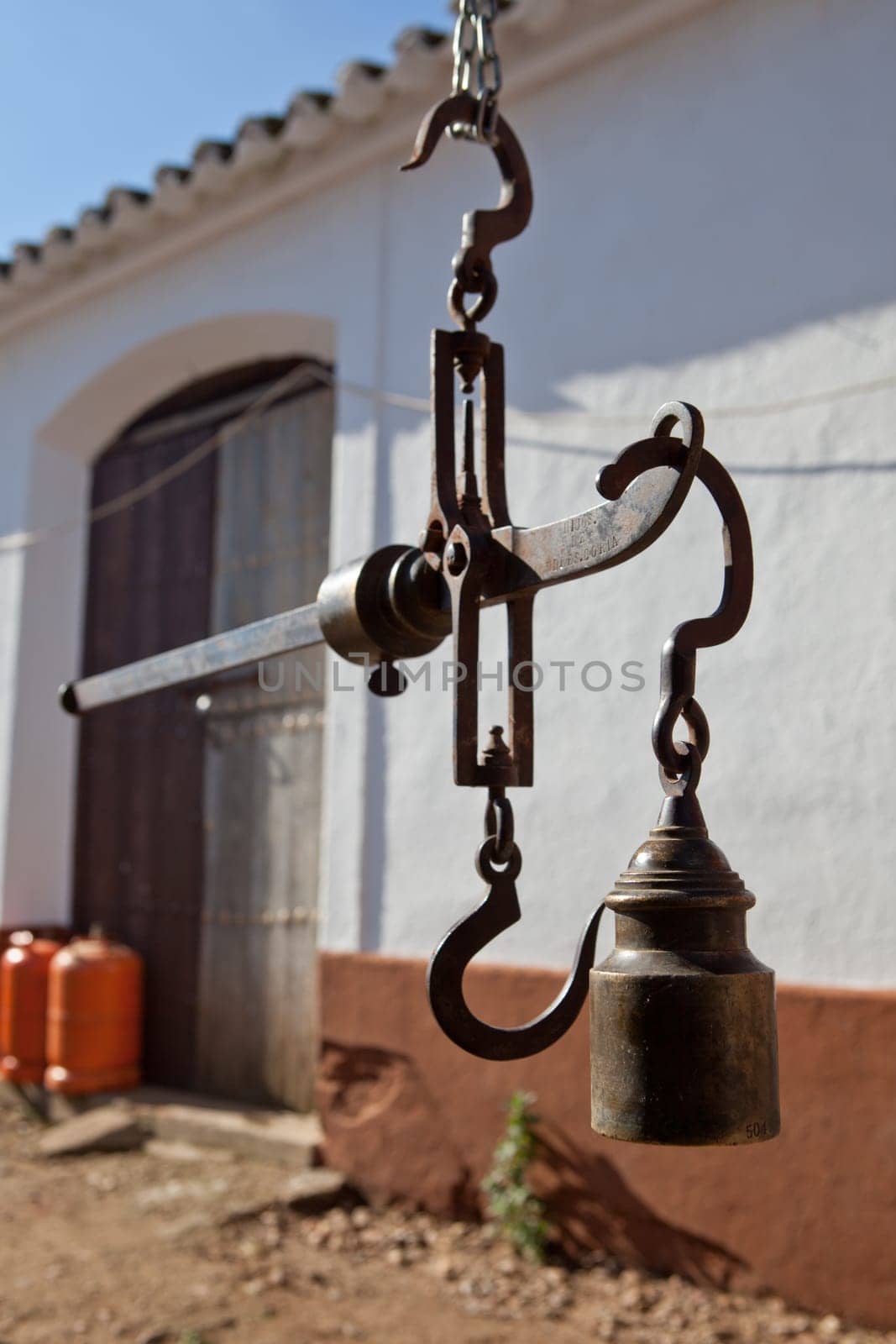 Hanging antique roman steelyard on a farm house, Badajoz, Spain