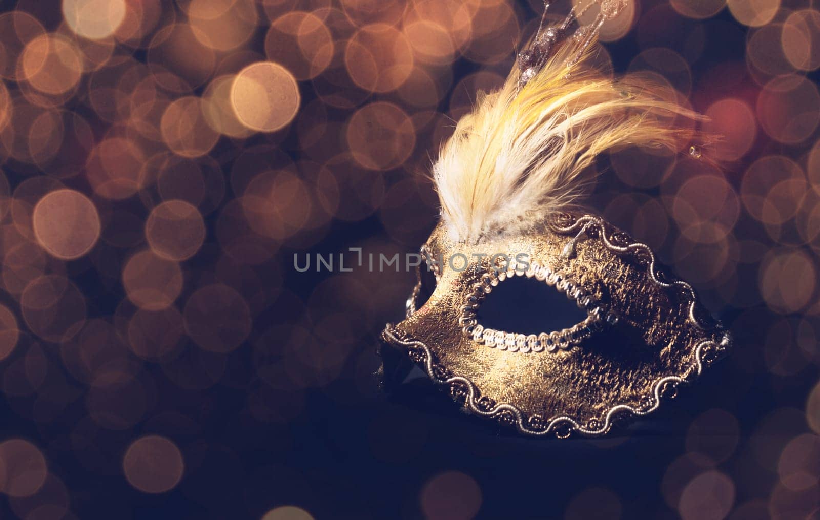 Golden venetian mask over black background