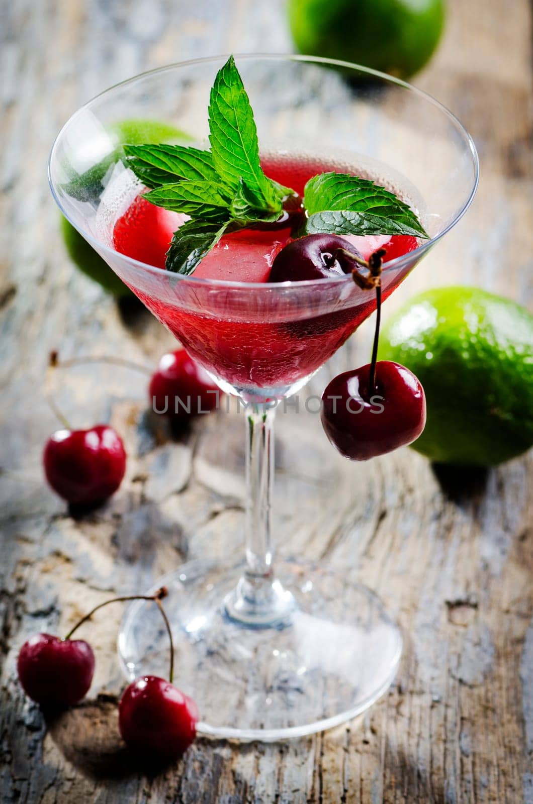Charry cocktail in martini glass on rustic table