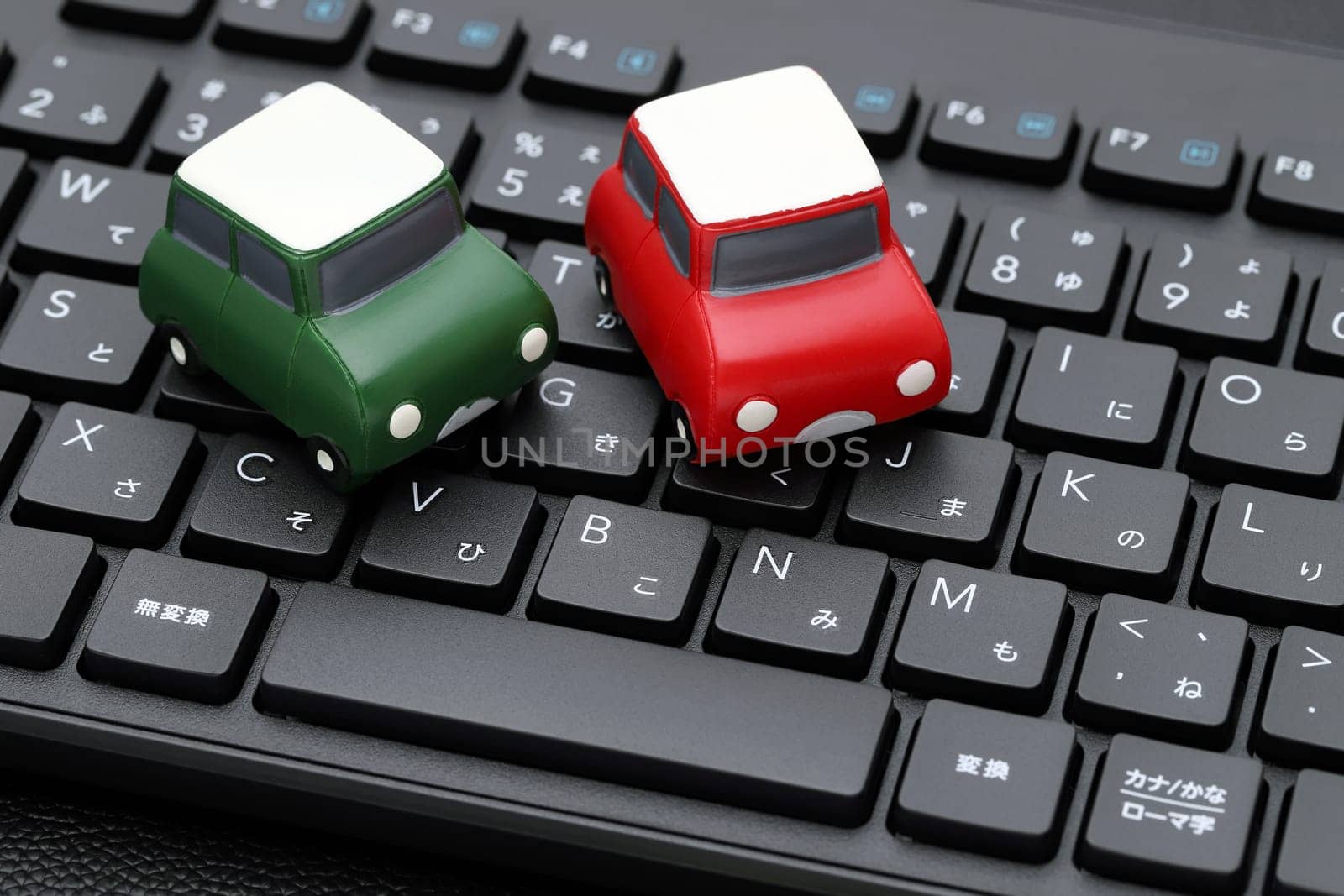 KAGAWA, JAPAN - FEBRUARY 23, 2022 - Small toy car on Alphabetics and Japanese hiragana typing keyboard.