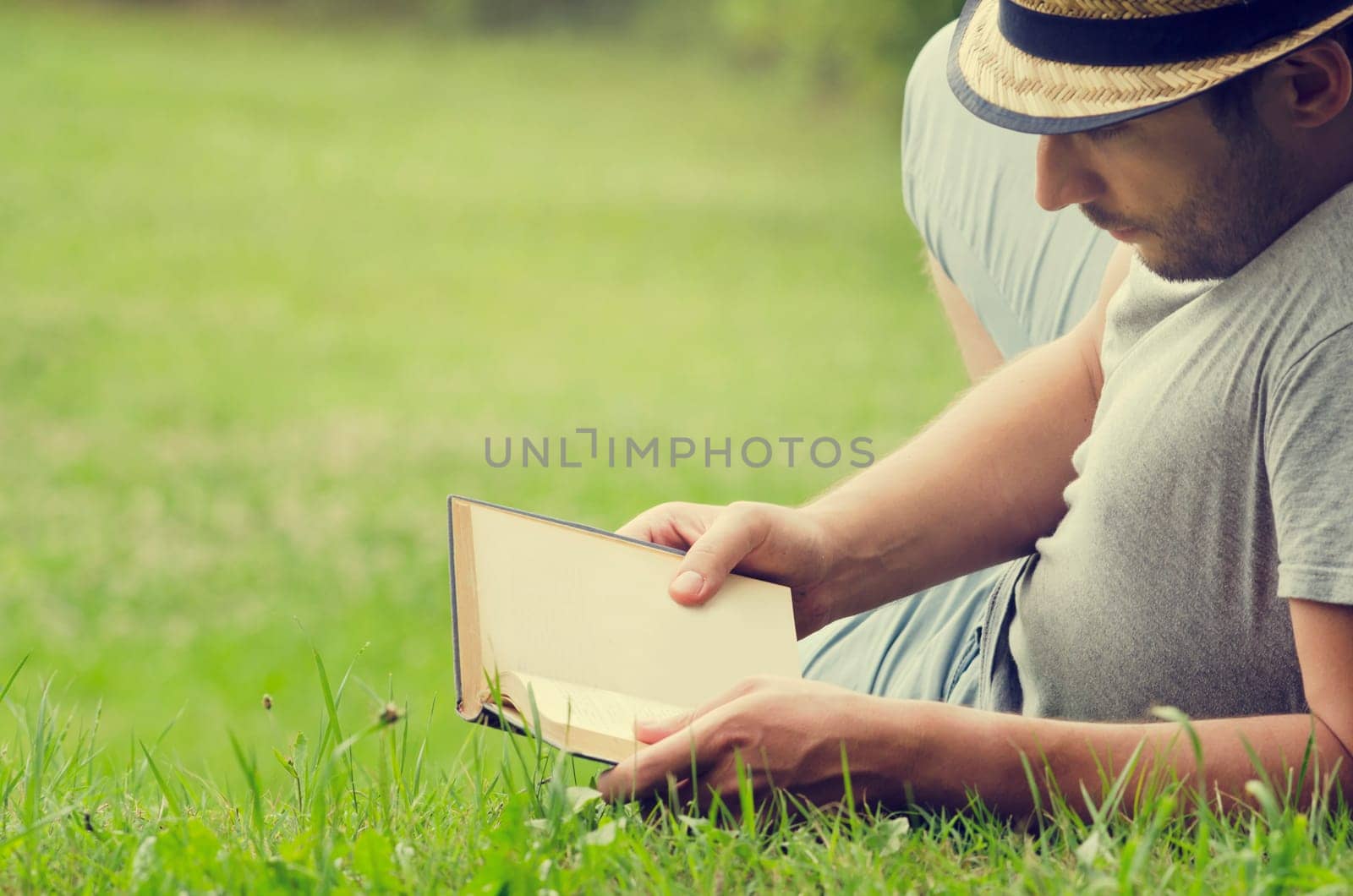 .Man reading a book on the grass