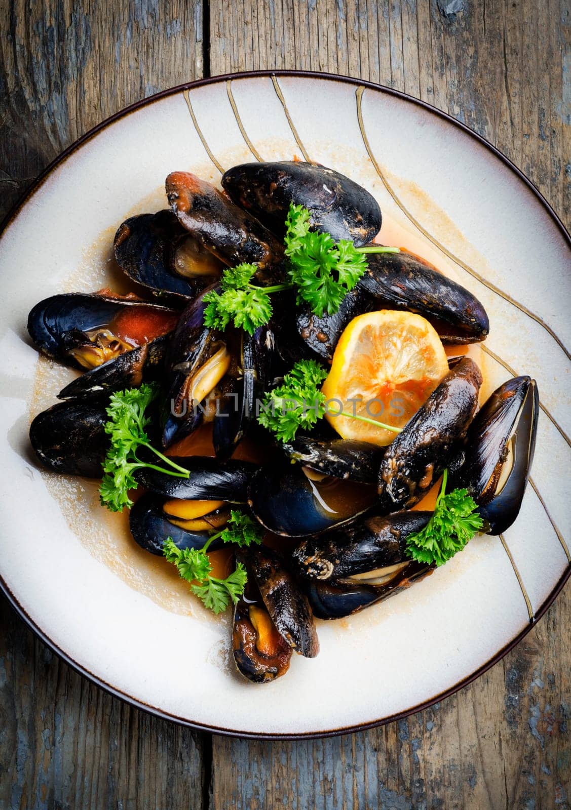 Mussels in tomato sauce on rustic wooden table