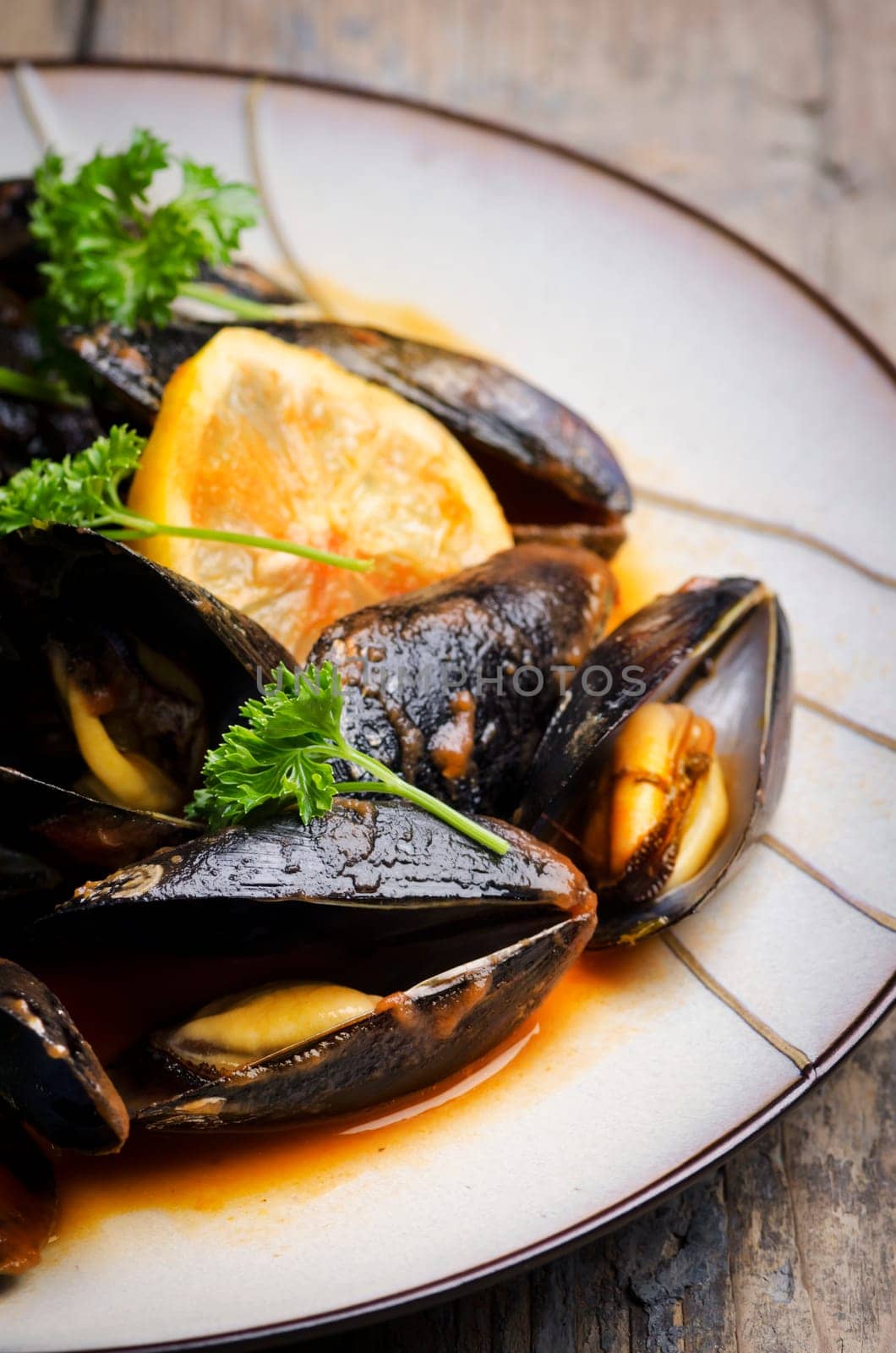 Mussels in tomato sauce on rustic wooden table