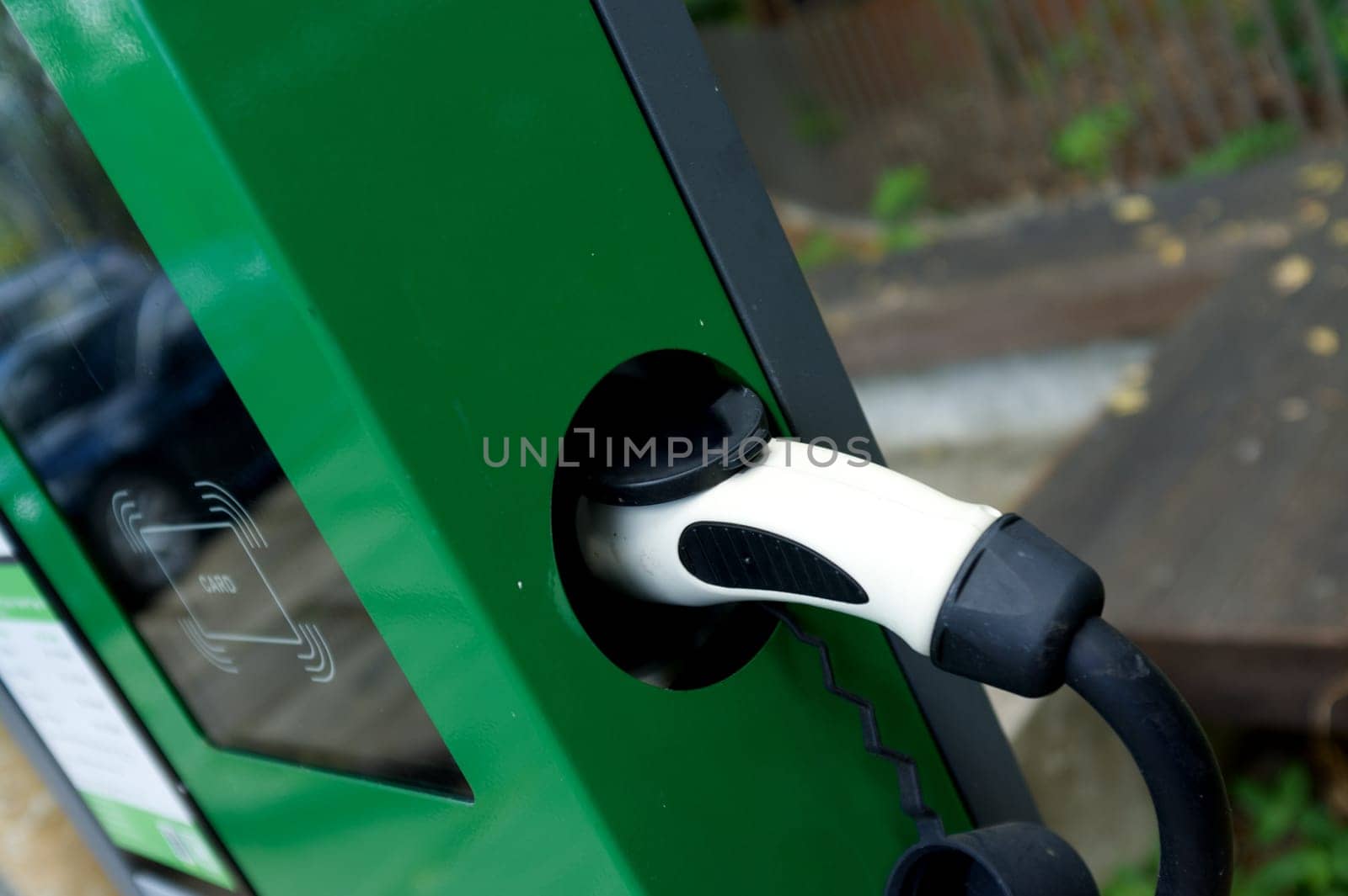 EV Car or Electric car at charging station with the power cable supply plugged .
