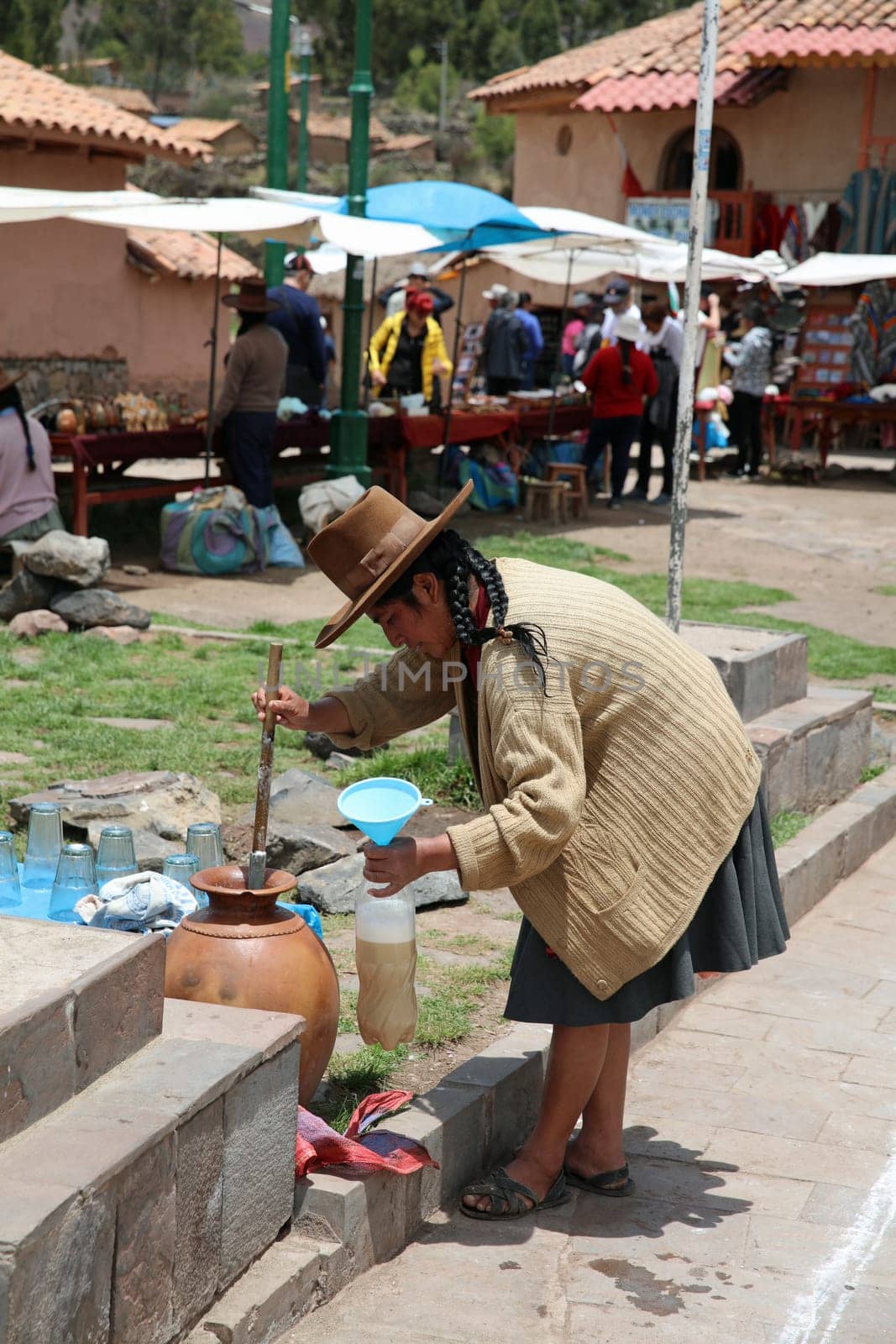 Woman is fetching a Drink in Raqui. Peru
