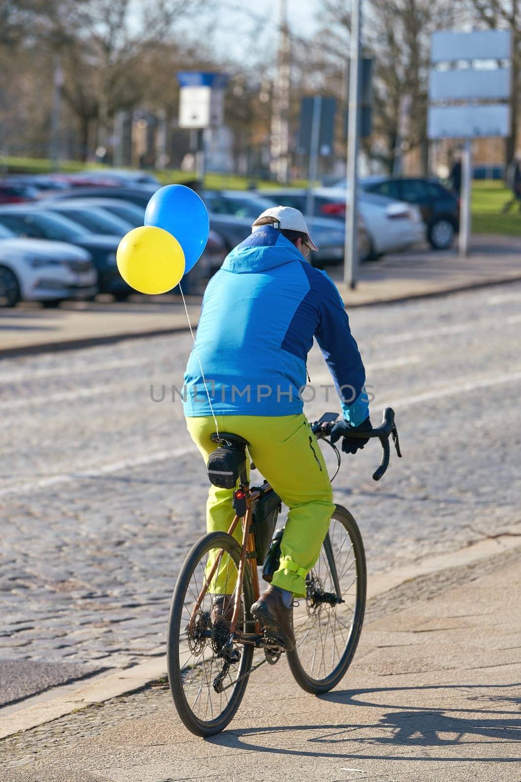 A cyclist wearing the colors of Ukraine on his way to a demonstration against the invasion of Russian troops in Ukraine in downtown Magdeburg, Germany
