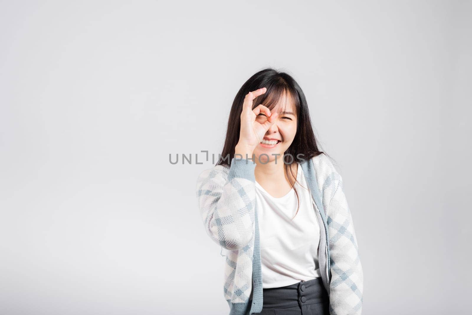 Woman smiling showing made finger OK symbol sign to agree studio shot isolated white background, Happy Asian portrait beautiful young female lifestyle agree hand sign with copy space
