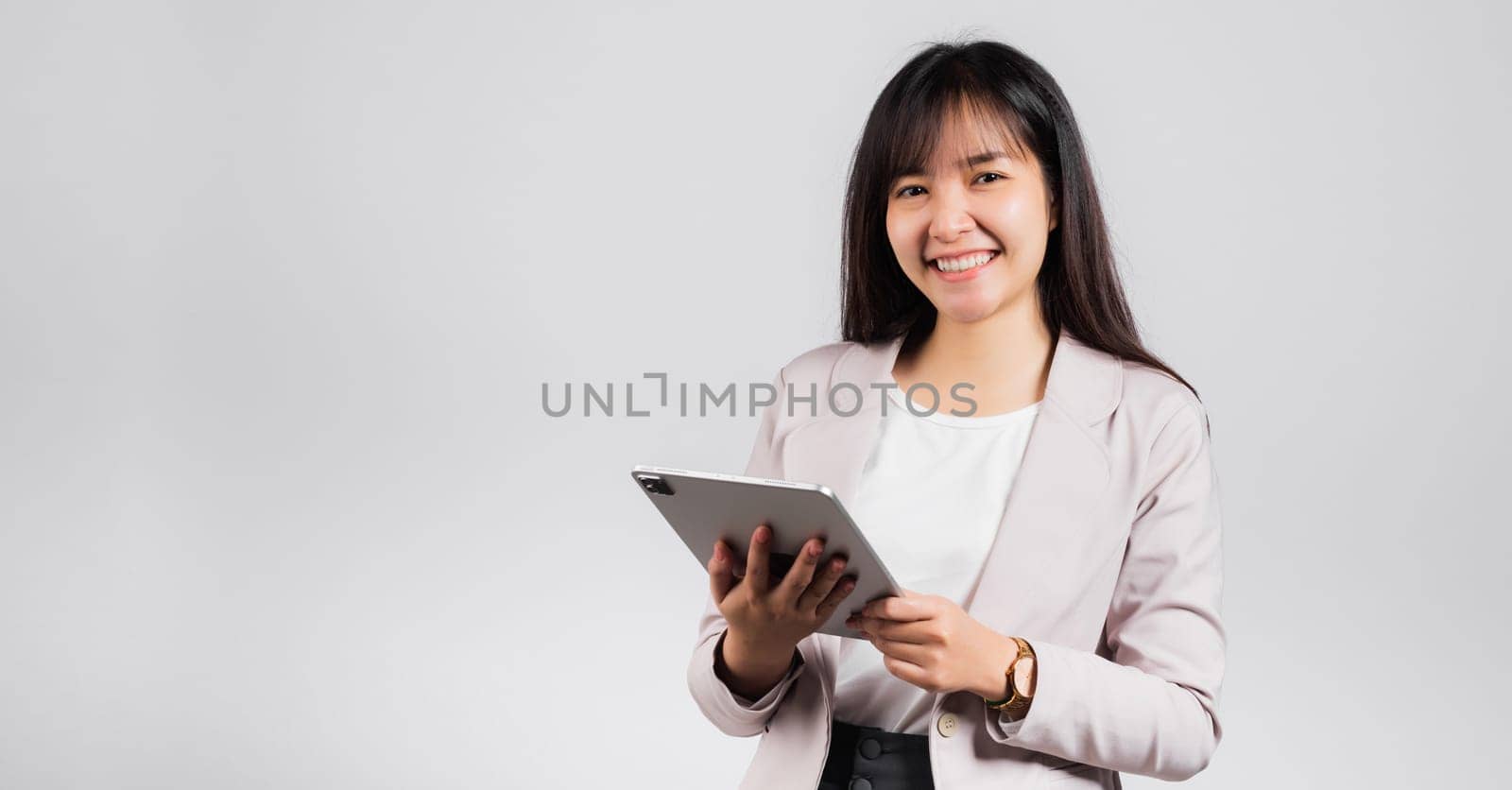 Portrait of Asian beautiful young woman smiling using tablet computer, Happy lifestyle female teen touching screen on digital tablet pc, studio shot isolated on white background