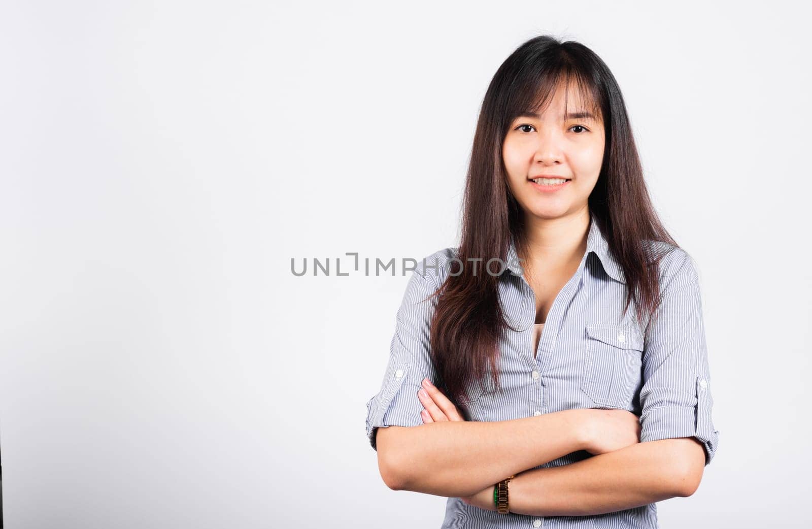 Woman standing her smile confidence with crossed arms isolated white background, Asian happy portrait beautiful young Thai female looking to camera in studio shot on white background and copy space