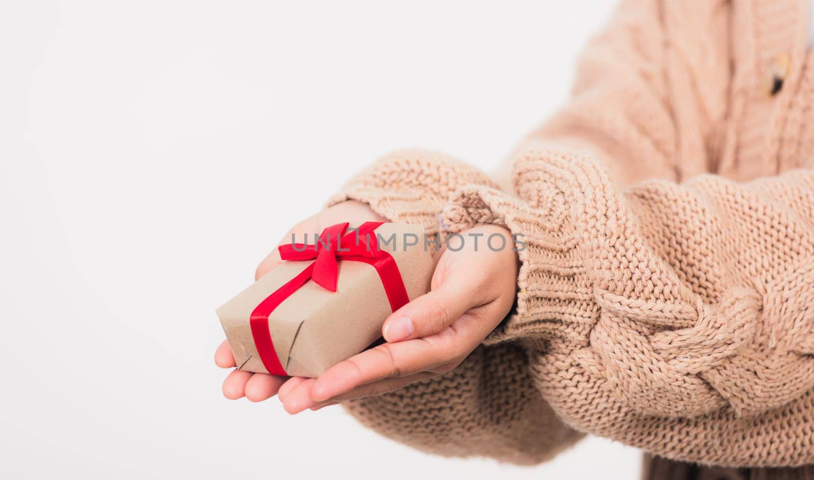 Valentine Day. Female beauty hands holding small gift package box present wrapped paper with ribbon isolated on white background, Christmas, New year, Birthday holiday background concept