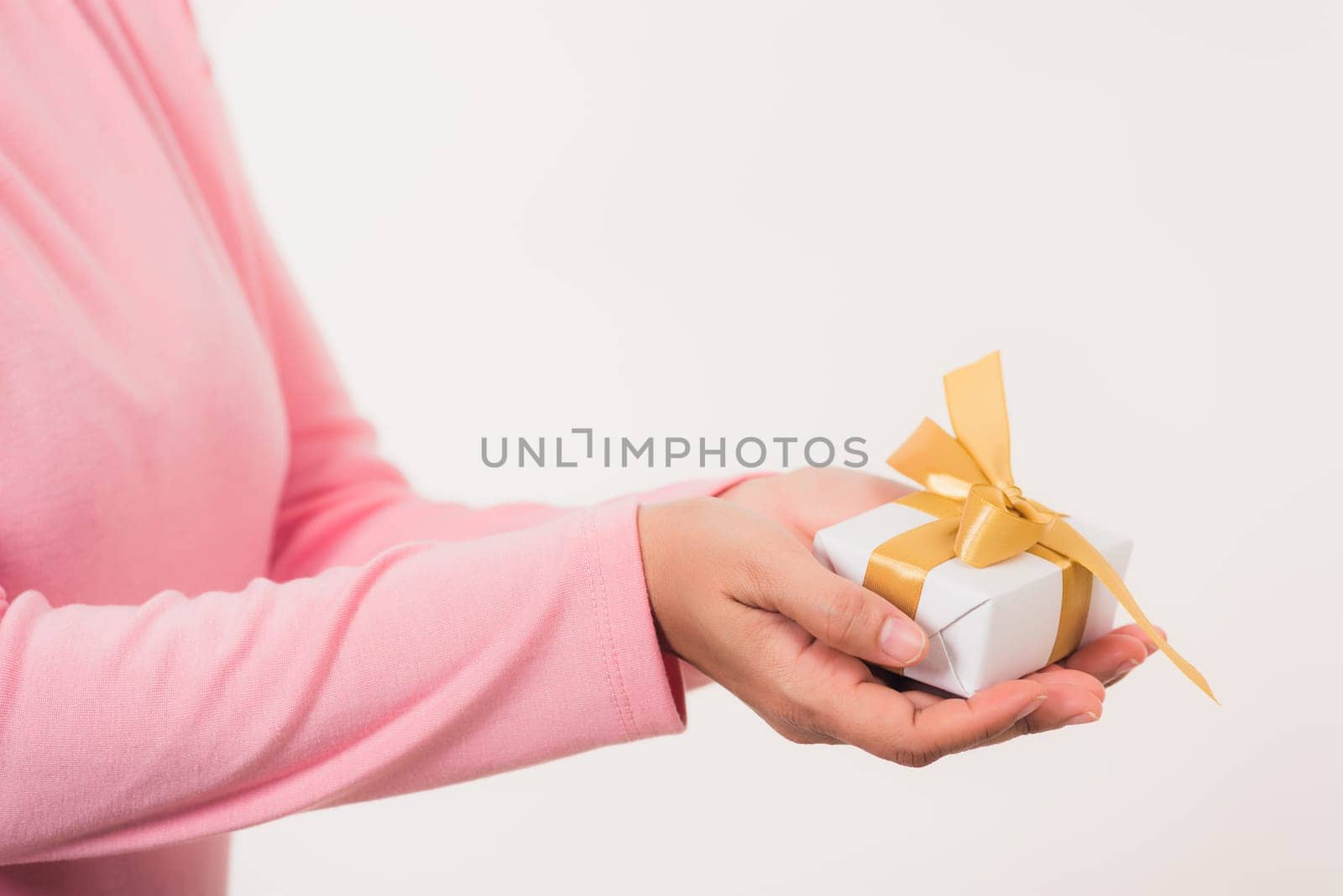 Valentine Day. Female beauty hands holding small gift package box present wrapped paper with ribbon isolated on white background, Christmas, New year, Birthday holiday background concept