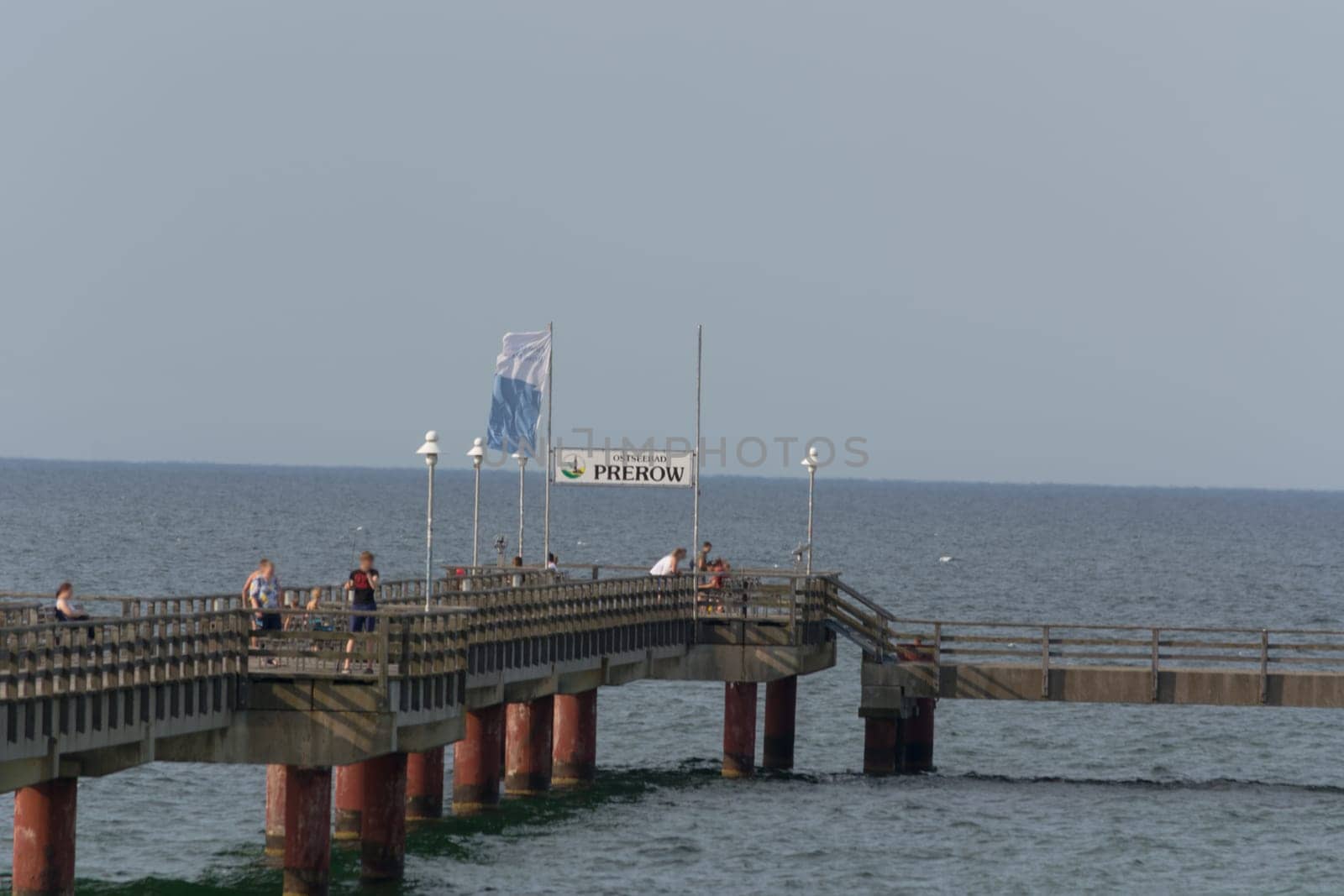 OSTSEEBAD PREROW,  GERMANY - JULY 31, 2018: ..Fishermen and tourists on the wooden pier of the Prerow seaside resort.