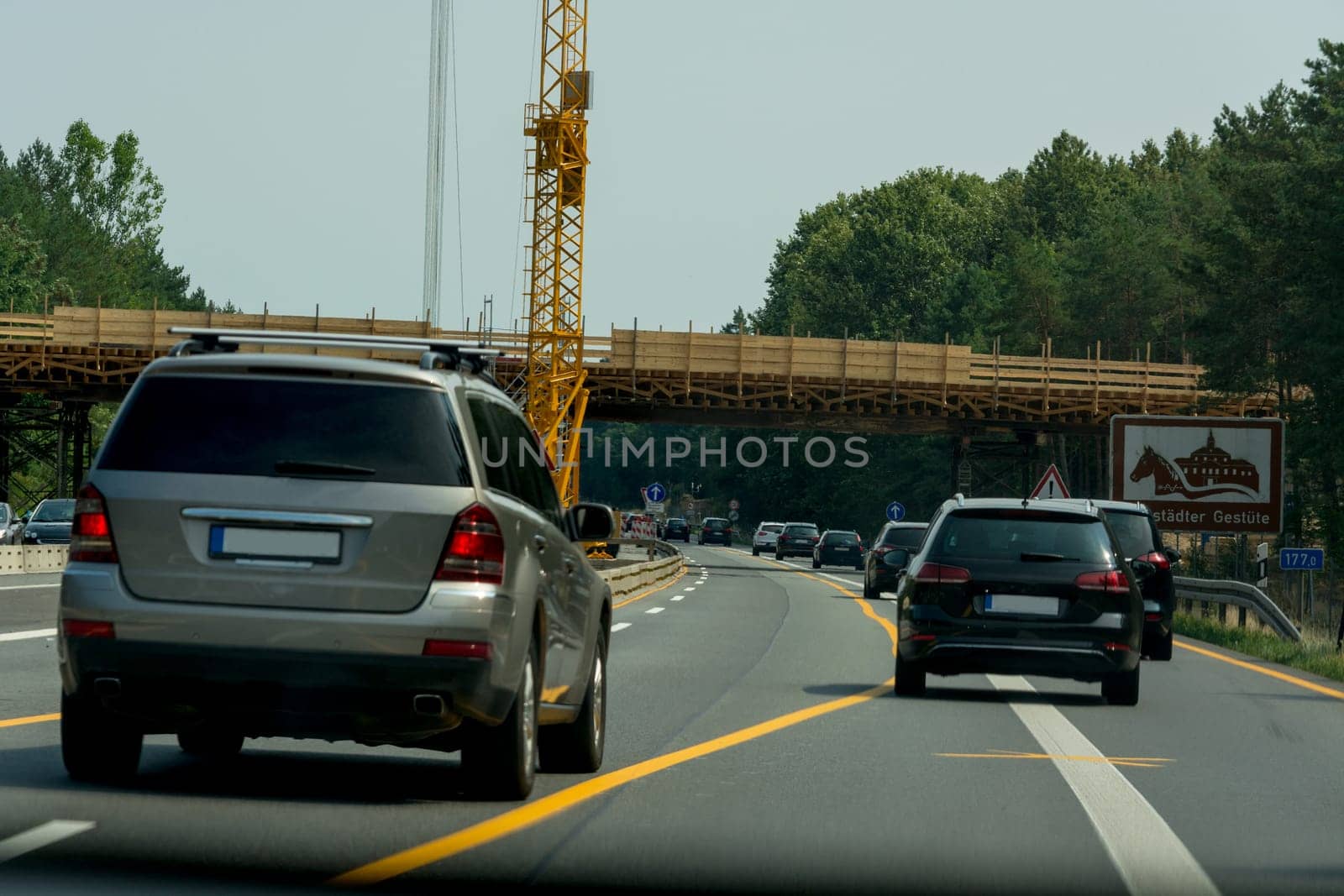 Various cars in a construction site area with construction crane on a german highway
