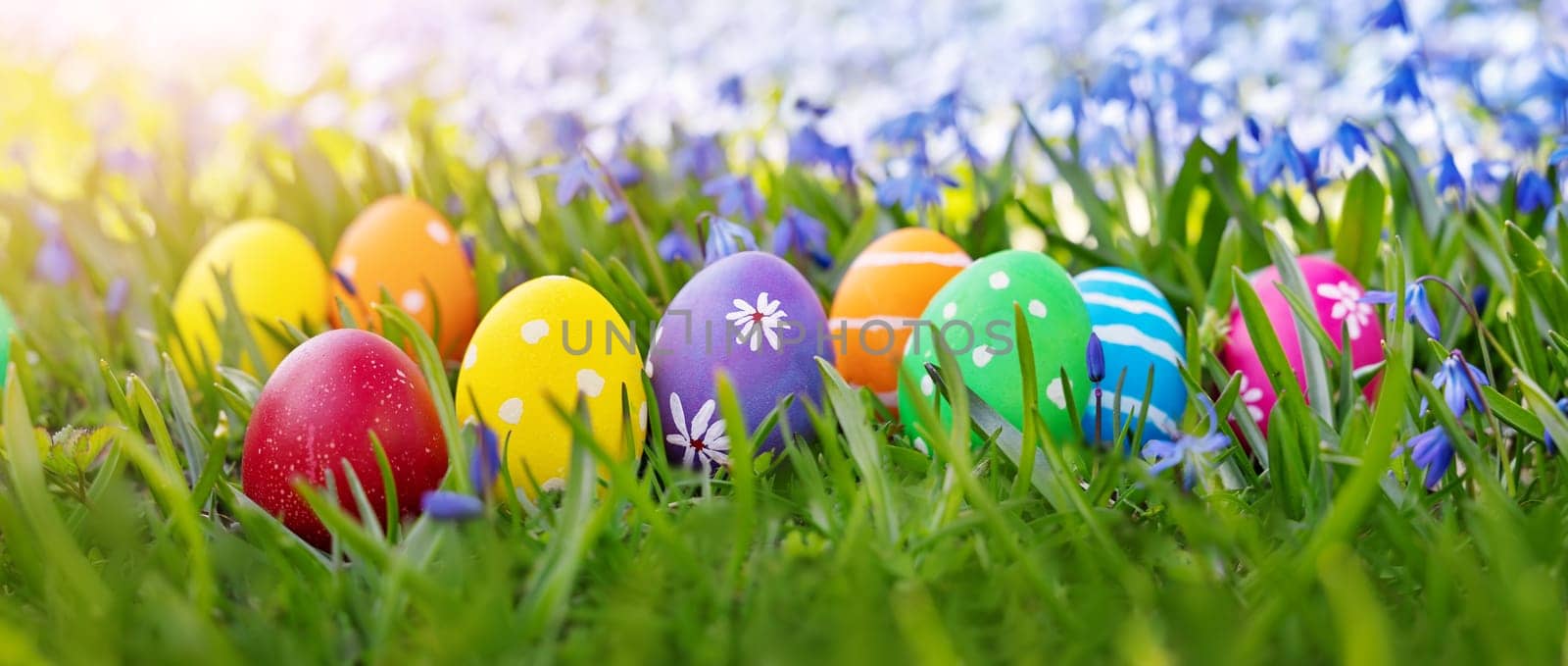 Easter eggs on the meadow with fresh green grass. Concept of the Easter celebration.