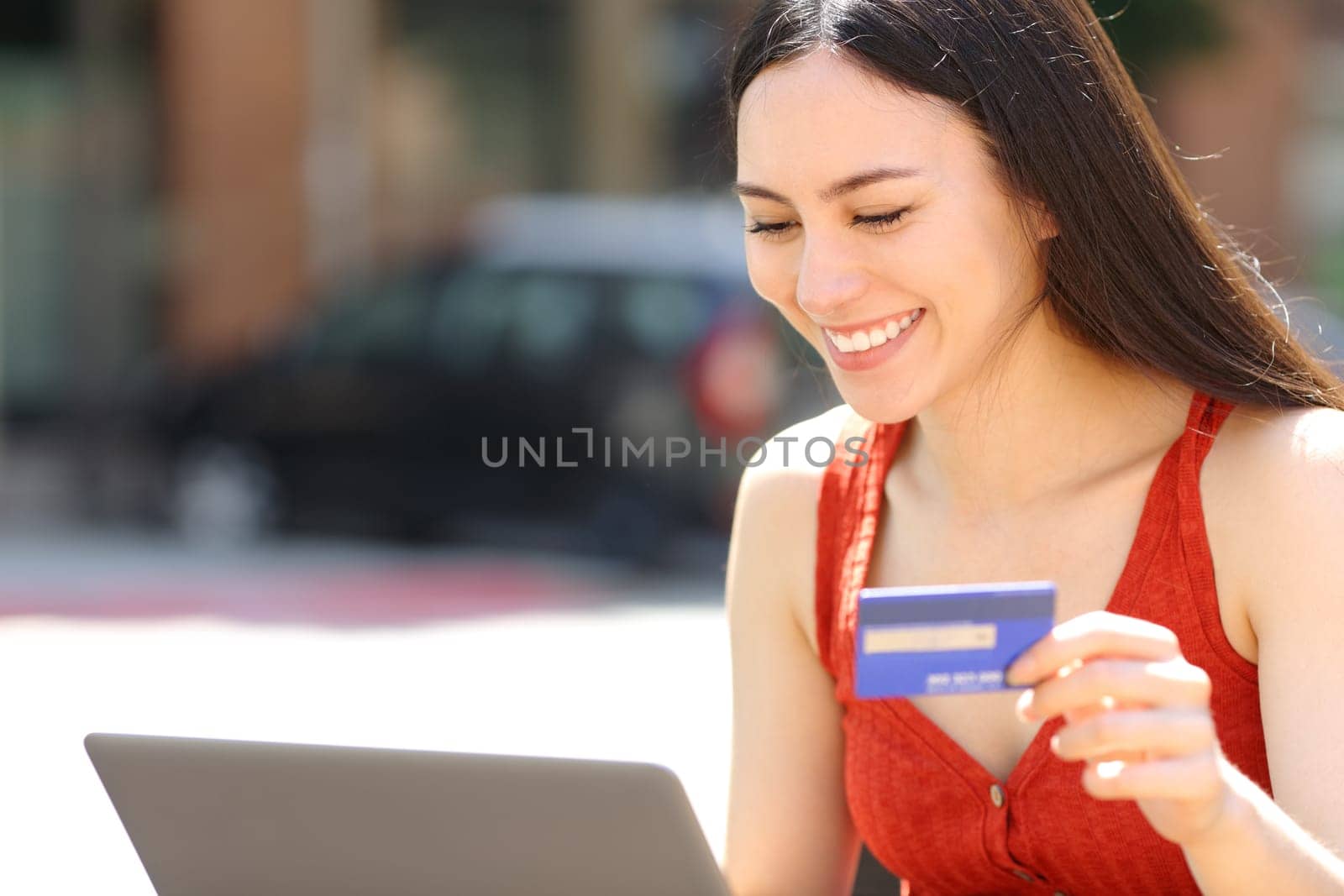 Happy asian woman paying online with credit card