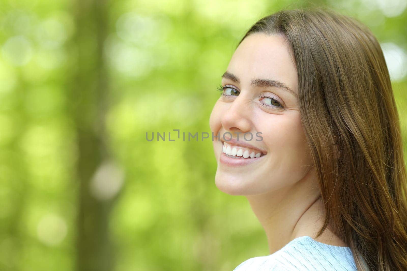 Beautiful woman looking at camera in a green park