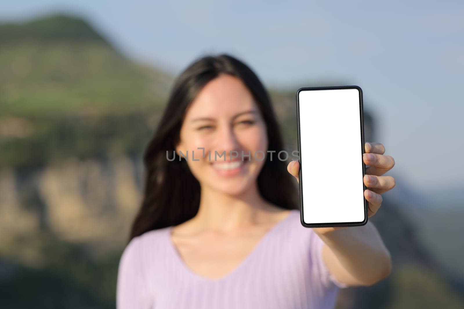 Happy asian woman showing blank smart phone screen