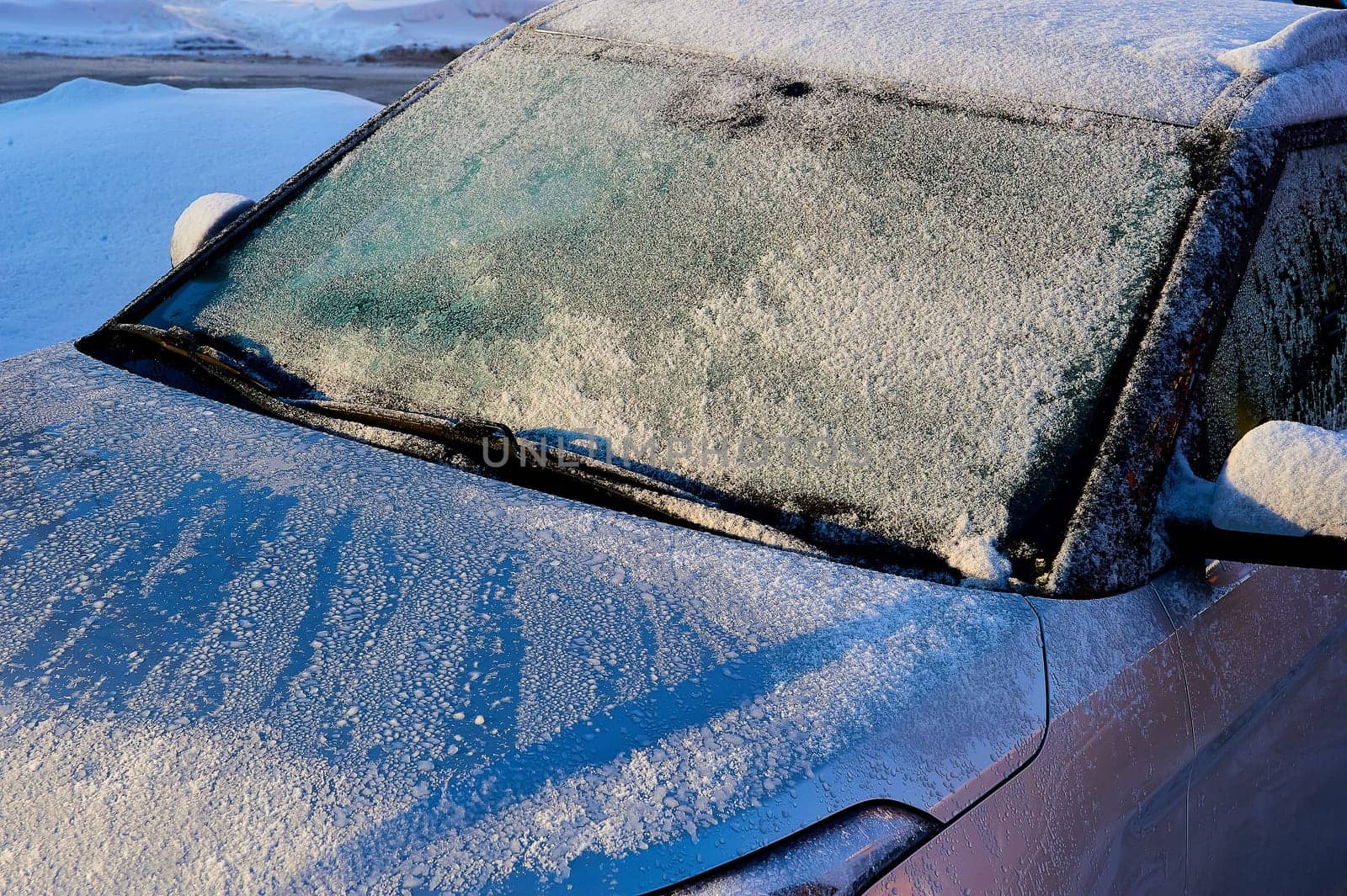 The windshield covered with frost at the car on a sun winter day. High quality photo