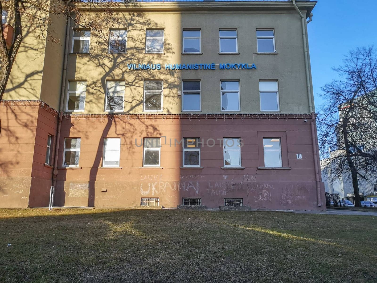 Vilnius, Lithuania. - 28.02.2022: The wall of the facade of the Vilnius Humanitarian School with children's inscriptions in chalk in Lithuanian: Freedom to Ukraine . Sign in Lithuanian Vilnius Humanitarian School