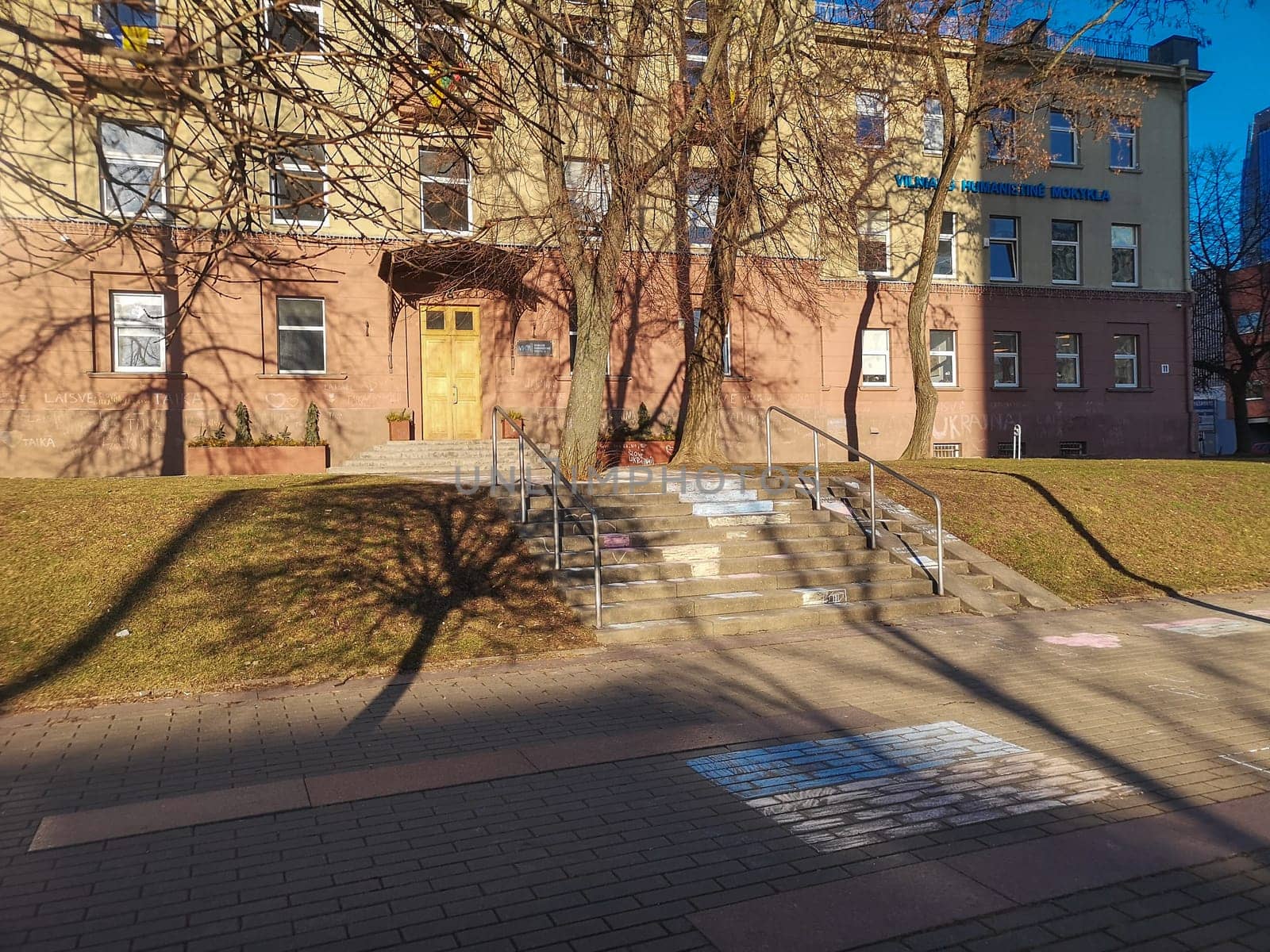 Vilnius, Lithuania. - 28.02.2022: Children's drawing with chalk of the Ukrainian flag in front of the entrance to the Vilnius Humanitarian School as a sign of support and solidarity with the Ukrainian nador against war and aggression.