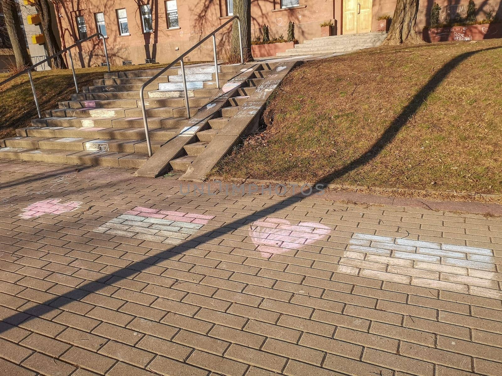 Vilnius, Lithuania. - 28.02.2022: Drawings in chalk of the Lithuanian and Ukrainian flags are made by children in front of the entrance to the Vilnius Humanitarian School in support of Ukraine against the war and Russian aggression.