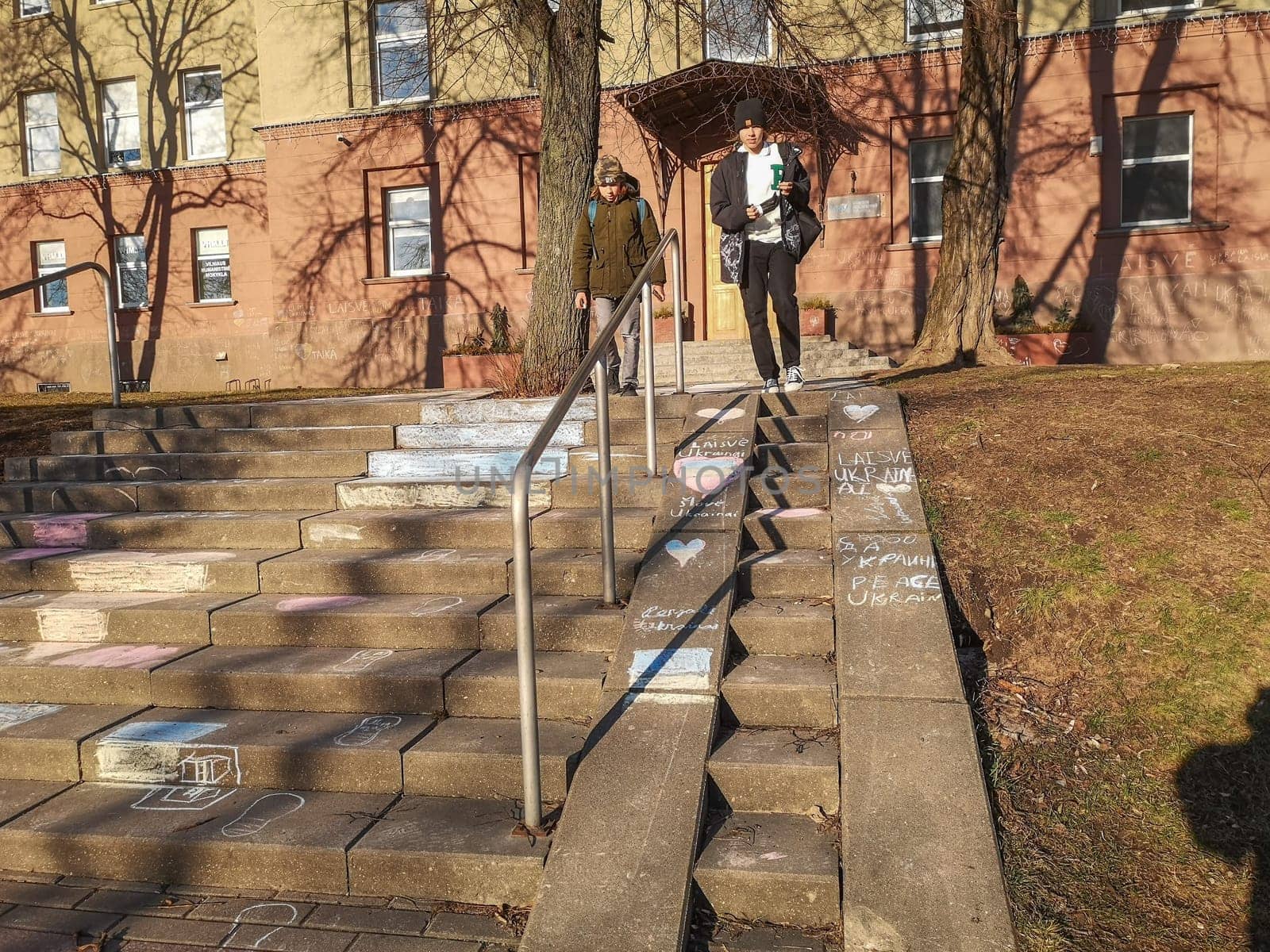 Vilnius, Lithuania. - 28.02.2022: Inscriptions in Lithuanian and Russian languages Freedom to Ukraine and children's drawings in chalk on the steps of the Vilnius Humanitarian School in solidarity with the people of Ukraine against the war and Russian aggression.