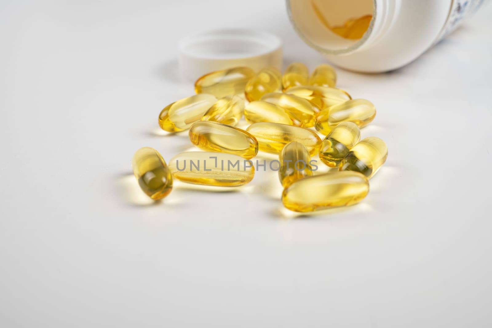 Gold fish oil isolated on white background. Pile of fish oil with Omega 3 acid vitamin D or Vitamin E