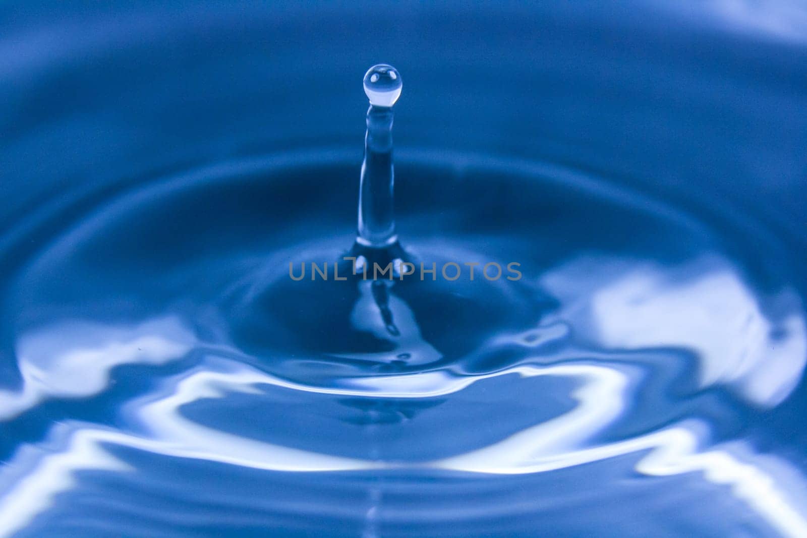 Wallpaper of drop falling on water and making ripples