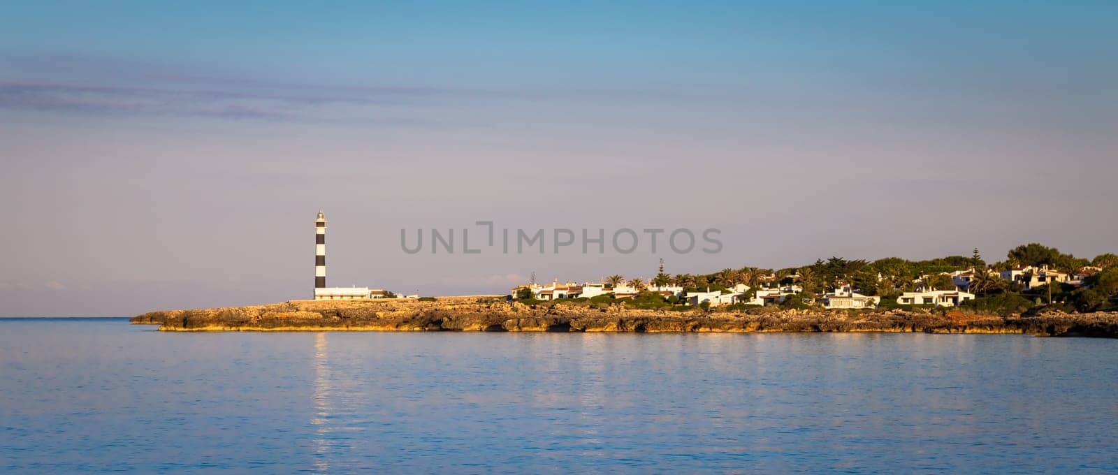 MINORCA ISLE - SPAIN - CIRCA AUGUST 2020: scenic Artrutx Lighthouse at sunset, famous landmark of the Isle