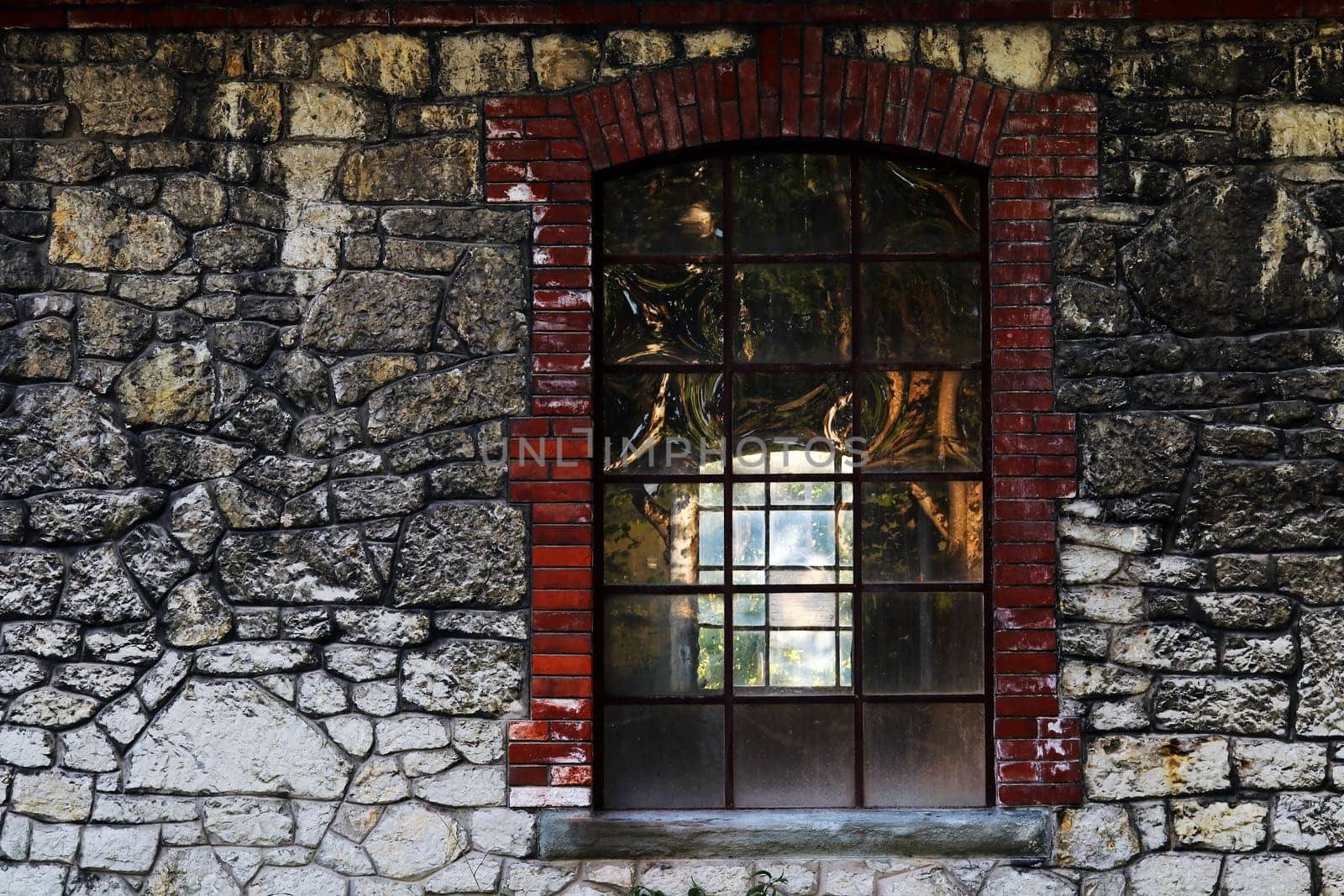 An old translucent window in a vacant building with stone wall