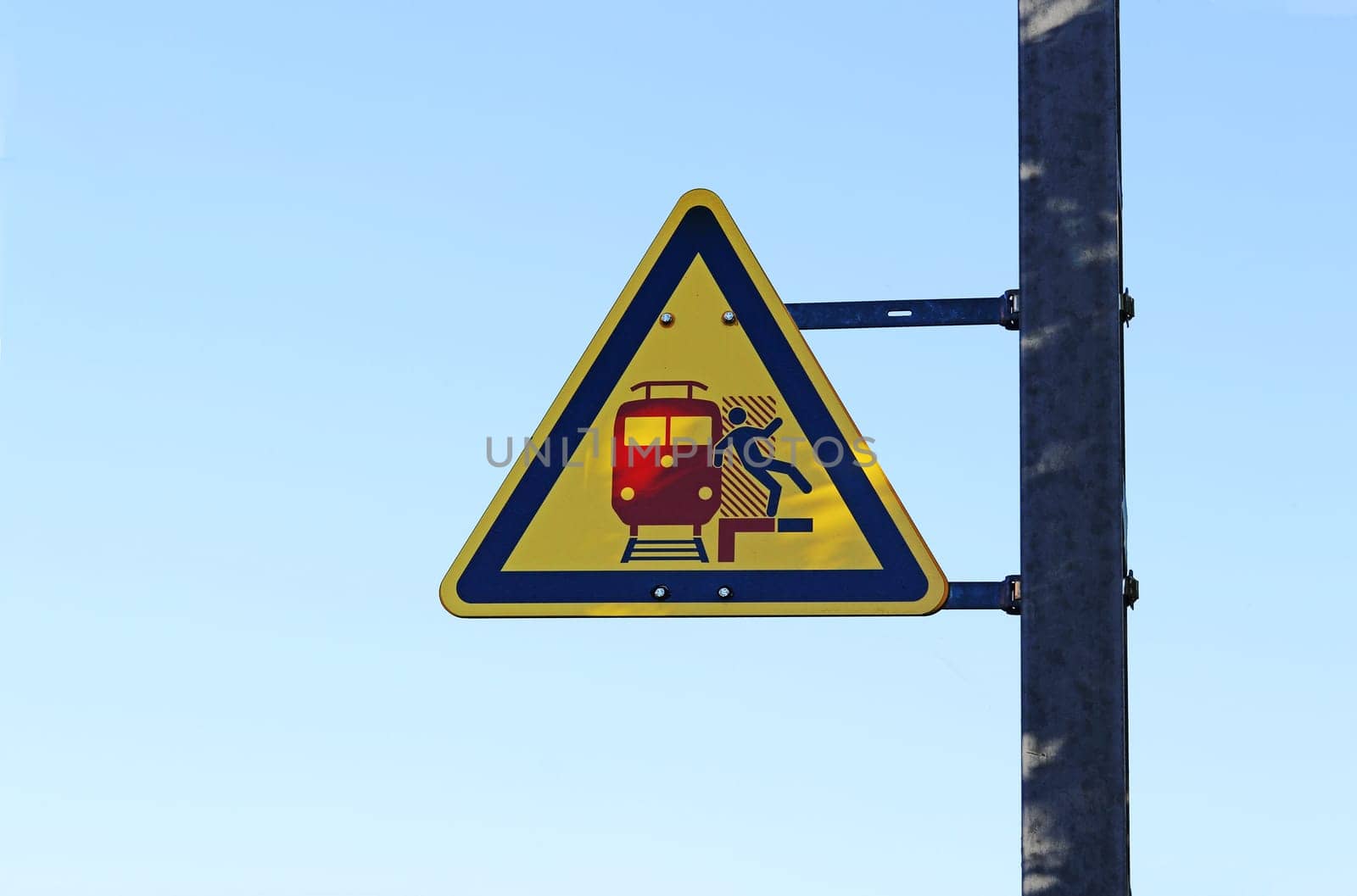 Warning sign at a train station. Attention danger with passing trains