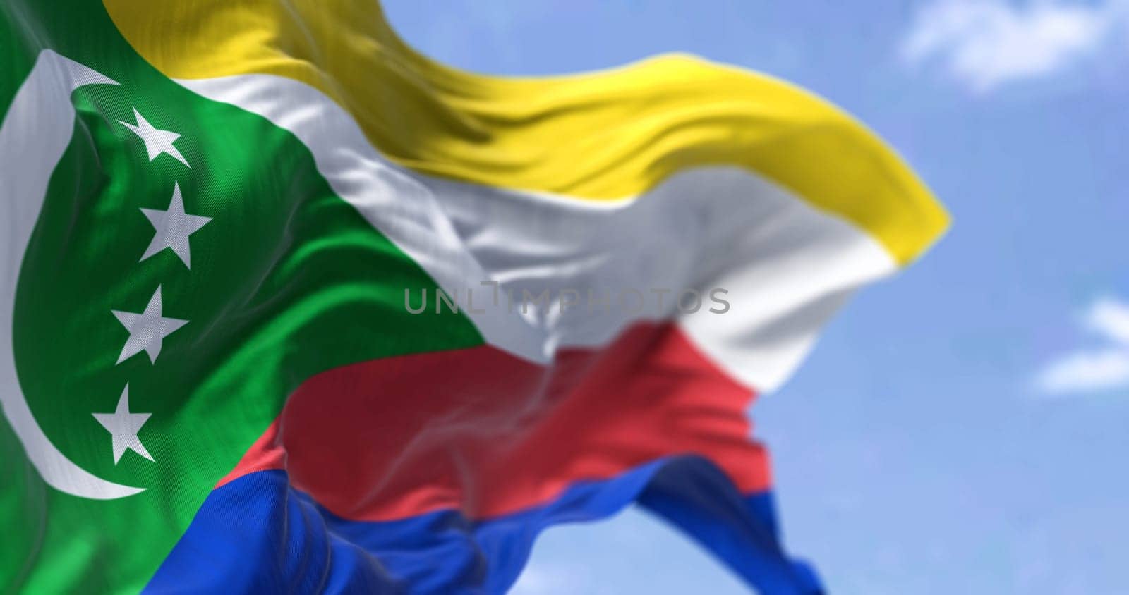 Detail of the national flag of Comoros waving in the wind on a clear day. Comoros is an archipelagic country in the Indian Ocean. Patriotism. Selective focus.