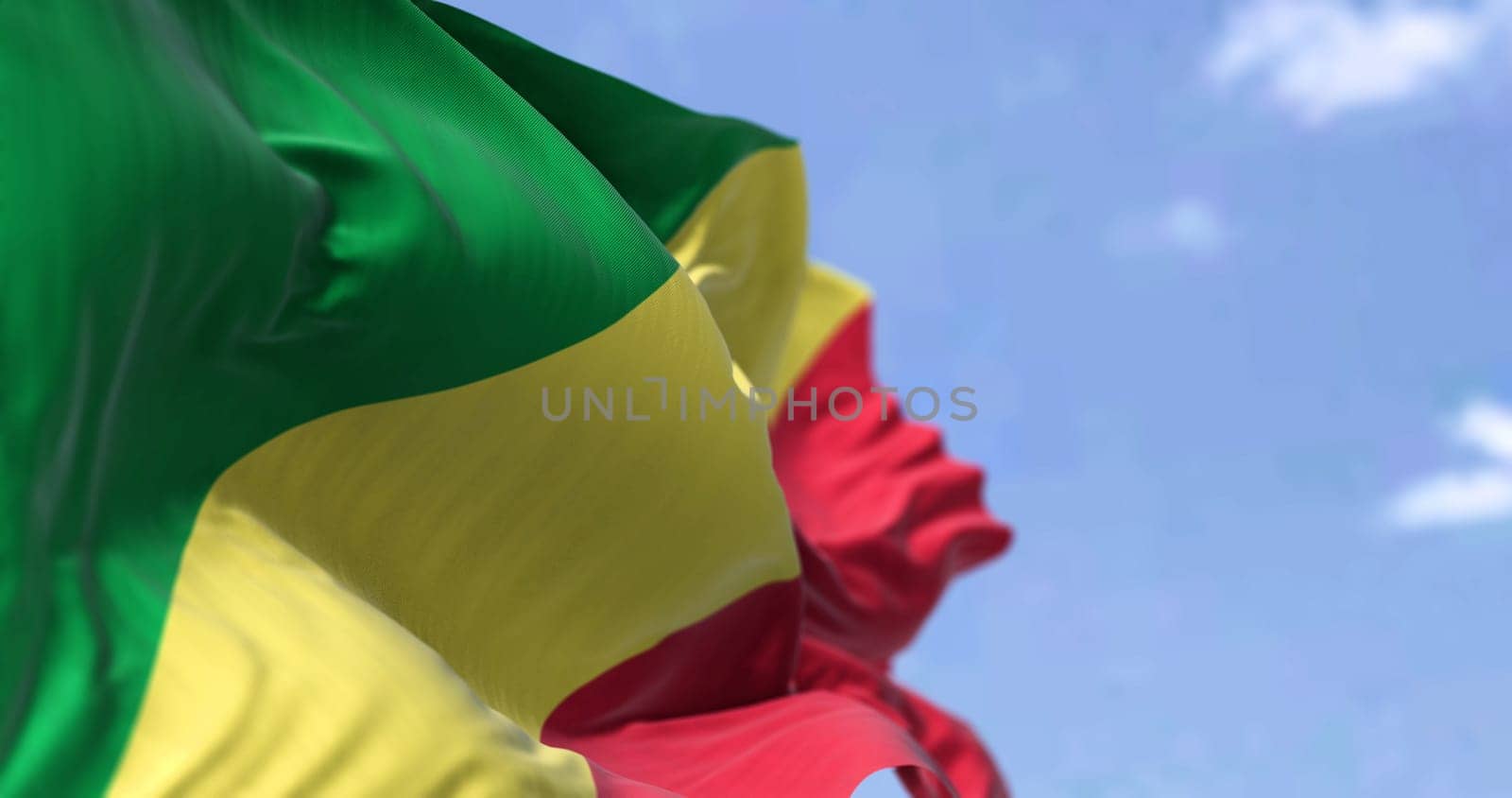 Detail of the national flag of Congo Republic waving in the wind on a clear day. Congo Republic is a country located in the western coast of Central Africa. Selective focus.