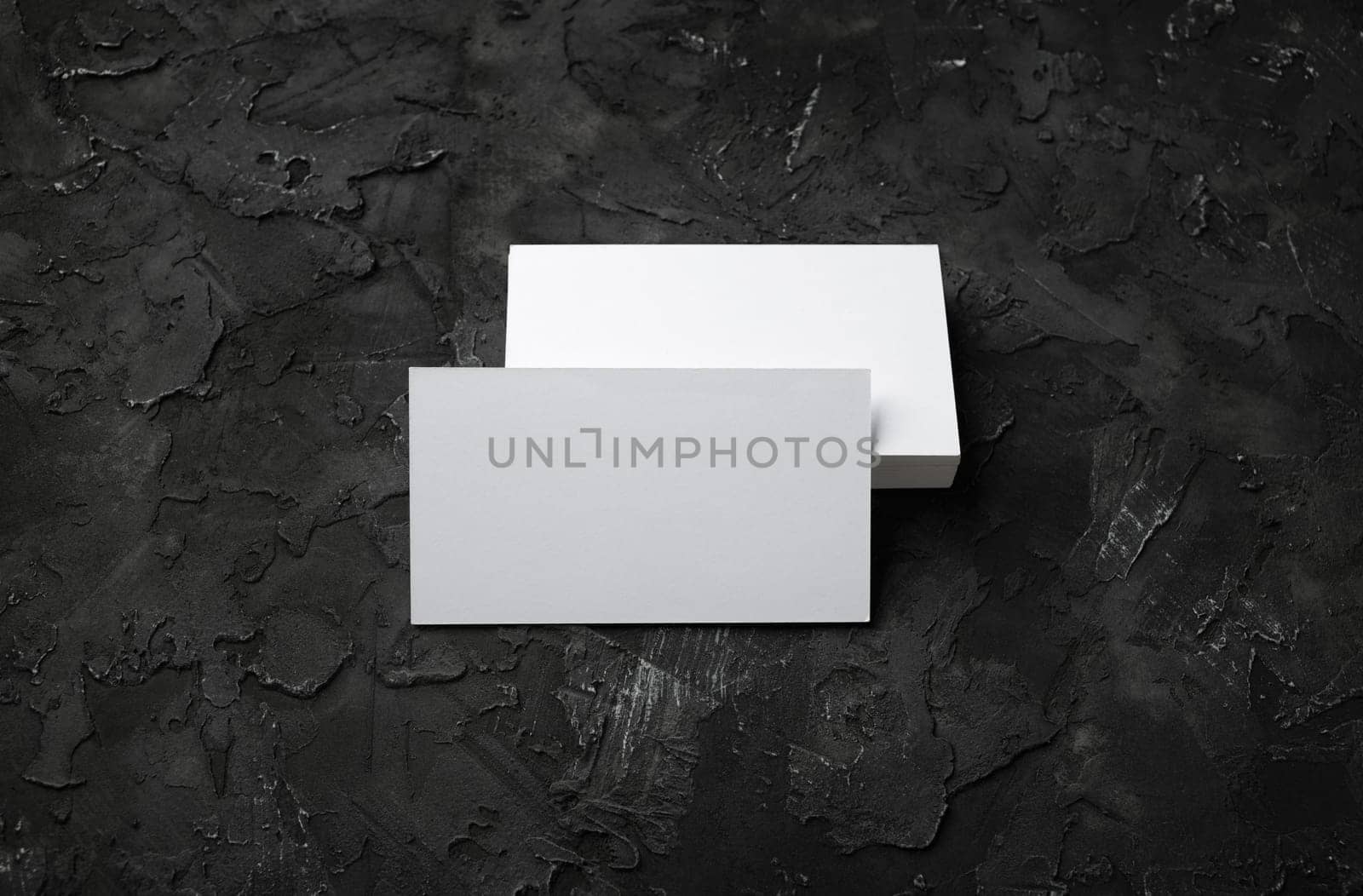 Photo of blank business cards on black stone background. Template for ID.