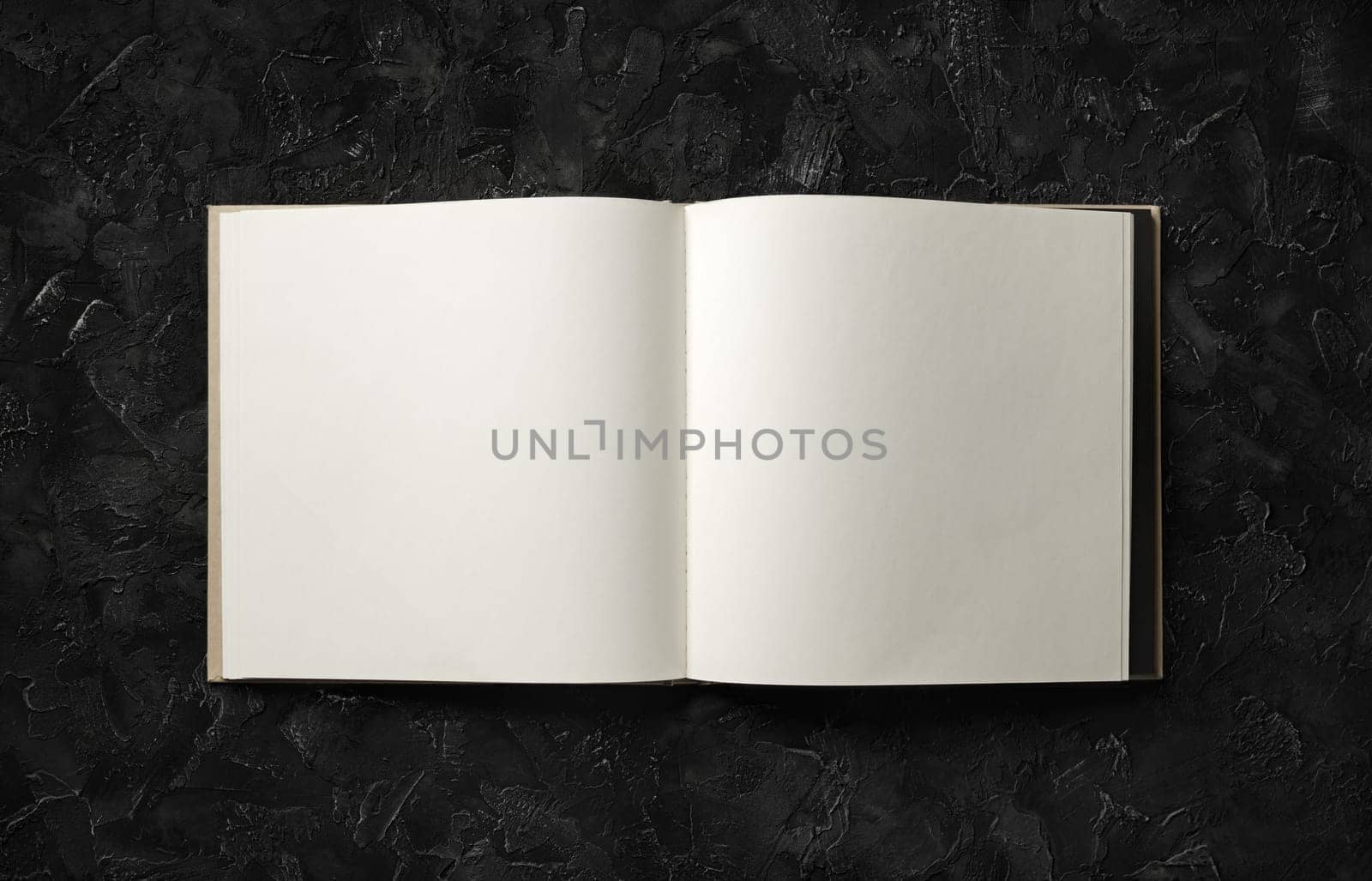 Blank brochure mock up on black stone background. Flat lay.