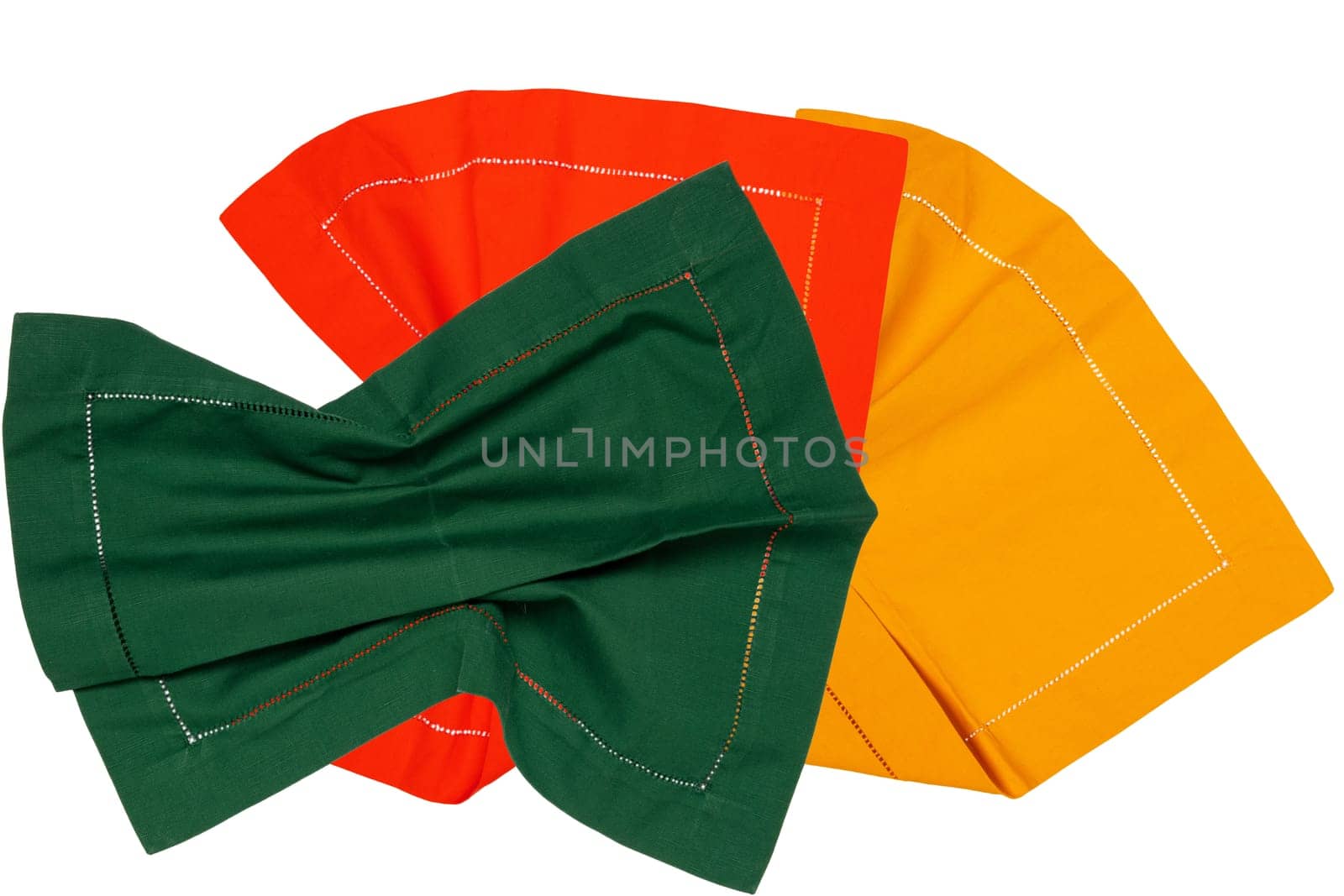 Closeup of a green, red and a yellow napkin or tablecloth isolated on a white background. Kitchen accessories. Top view