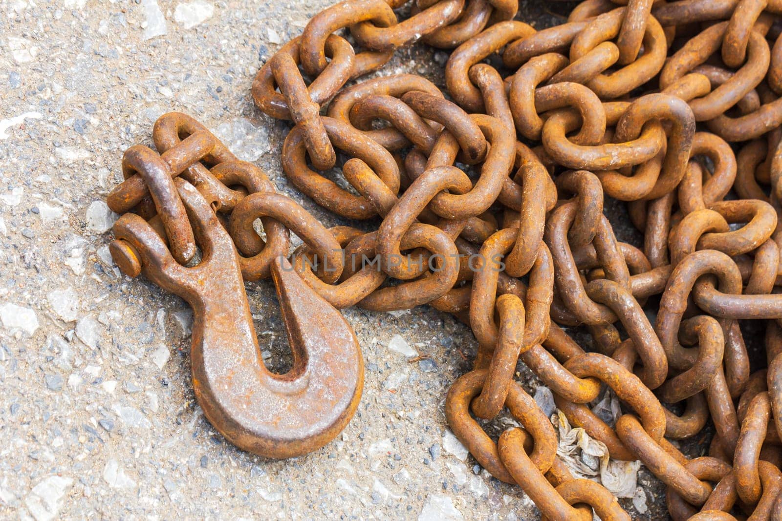 Close up Rusty hook and steel chain for industrial on floor