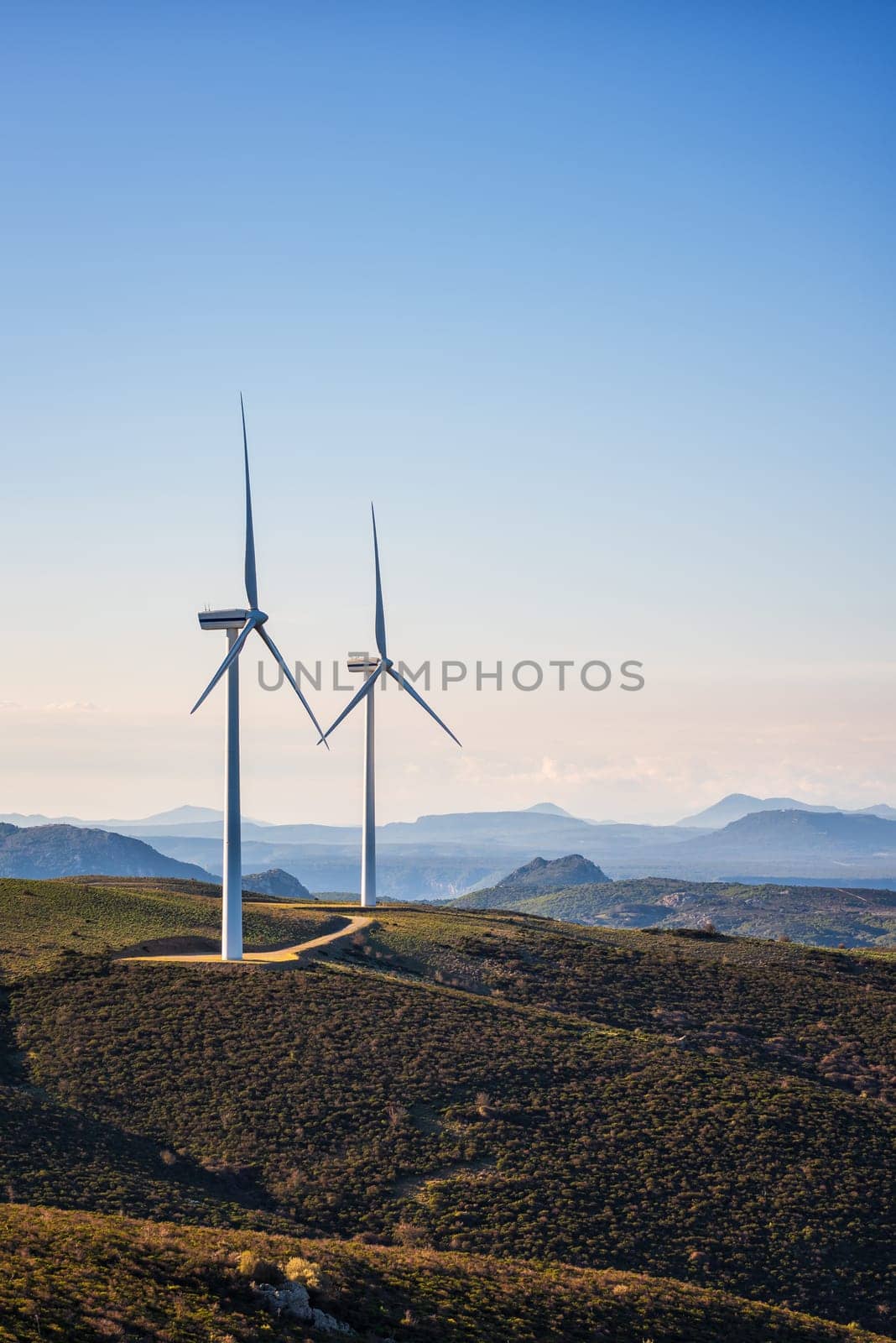 Wind turbines on a beautiful blue sky in a mountain wind farm in Sardinia. Renewable energy concept, green energy generation. Energy industry.