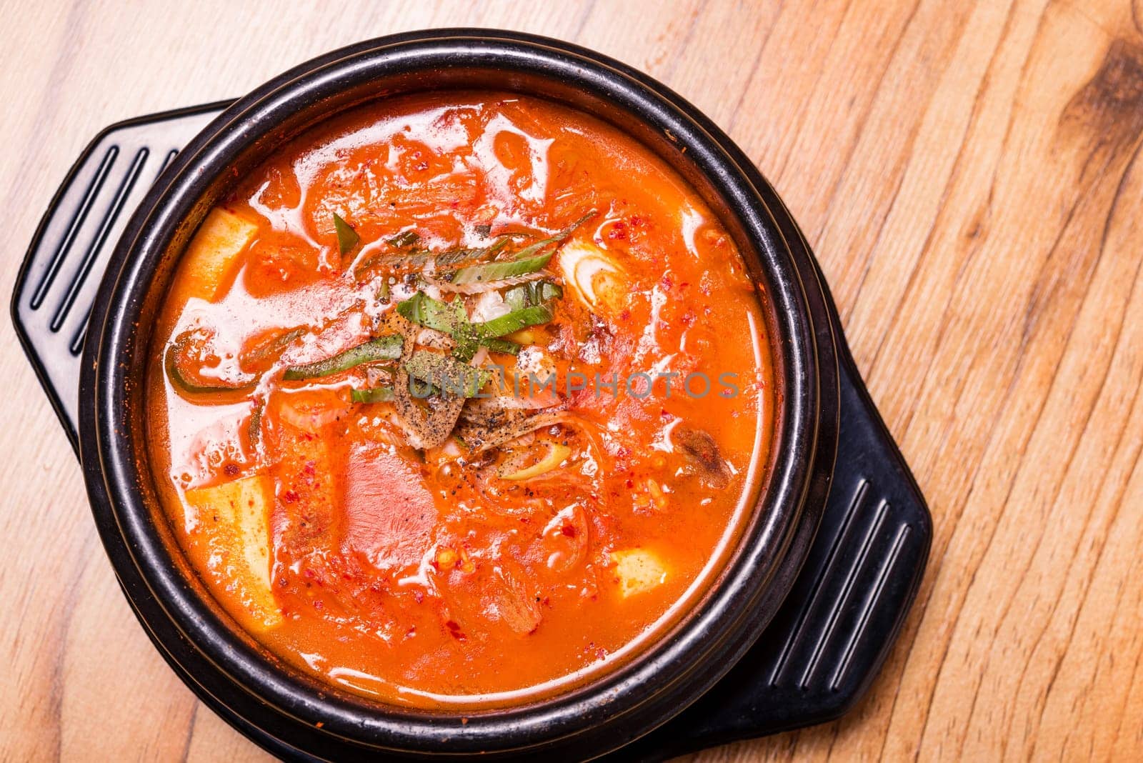 Kimchi soup in hot black iron pot, Korean traditional Kimchi Jjigae soup in bowl in the restaurant, Japanese hot pot food