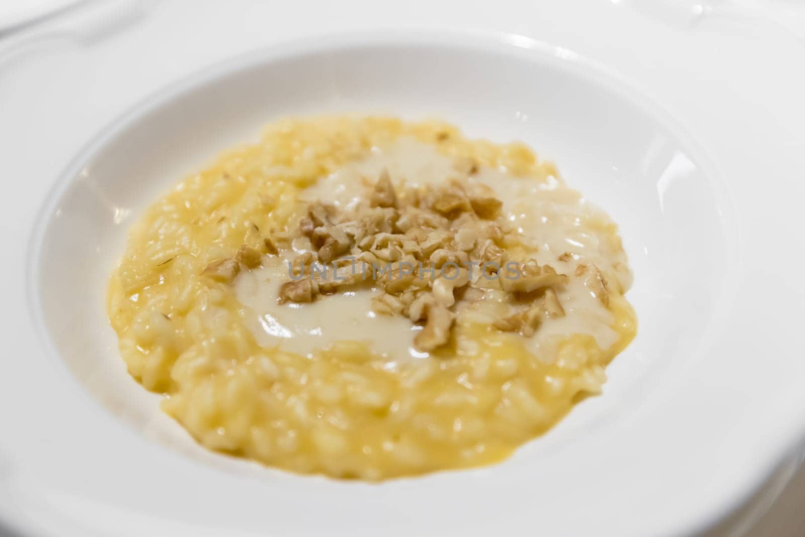 Saffron risotto with nuts. Italian dish made from saffron, rice and vegetable bouillon and nuts. Close-up.