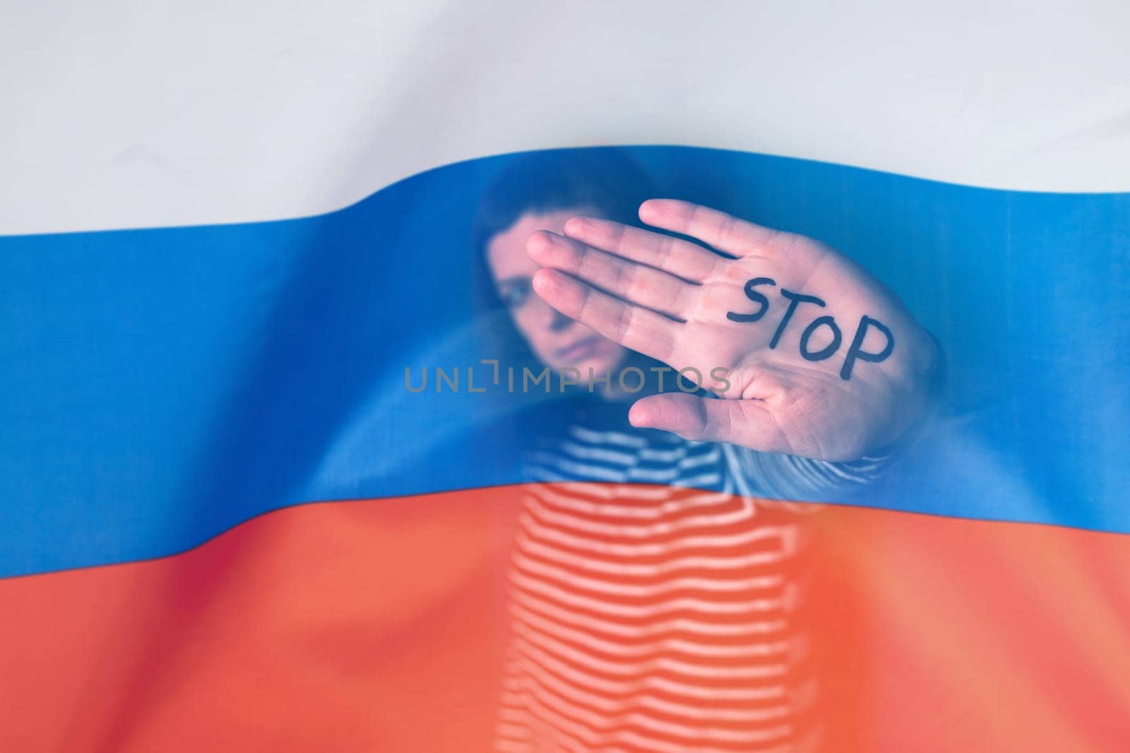 War between Russia and Ukraine. Woman with sad sight, Stop text over Russian flag.