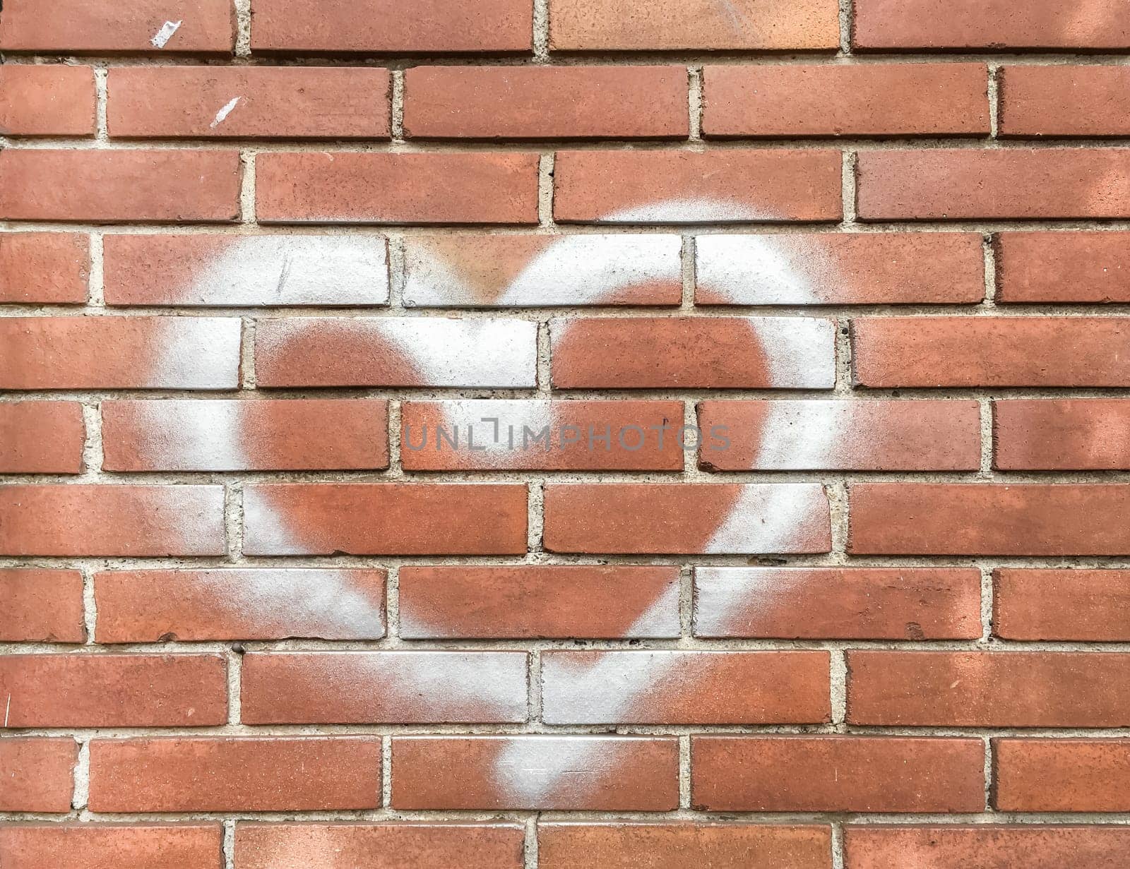 White heart painted on red brick wall. Love concept.