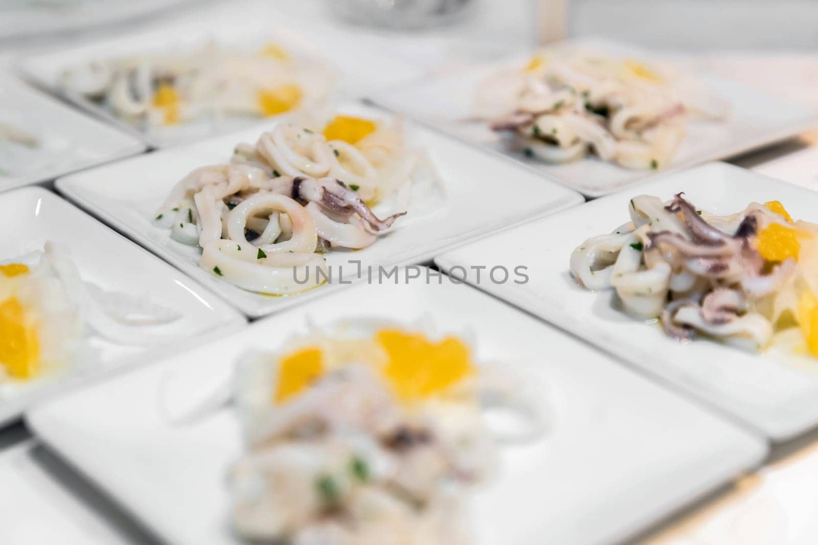 Fresh squid fish dishes, ready to be served to guests. Wedding, appetizers.