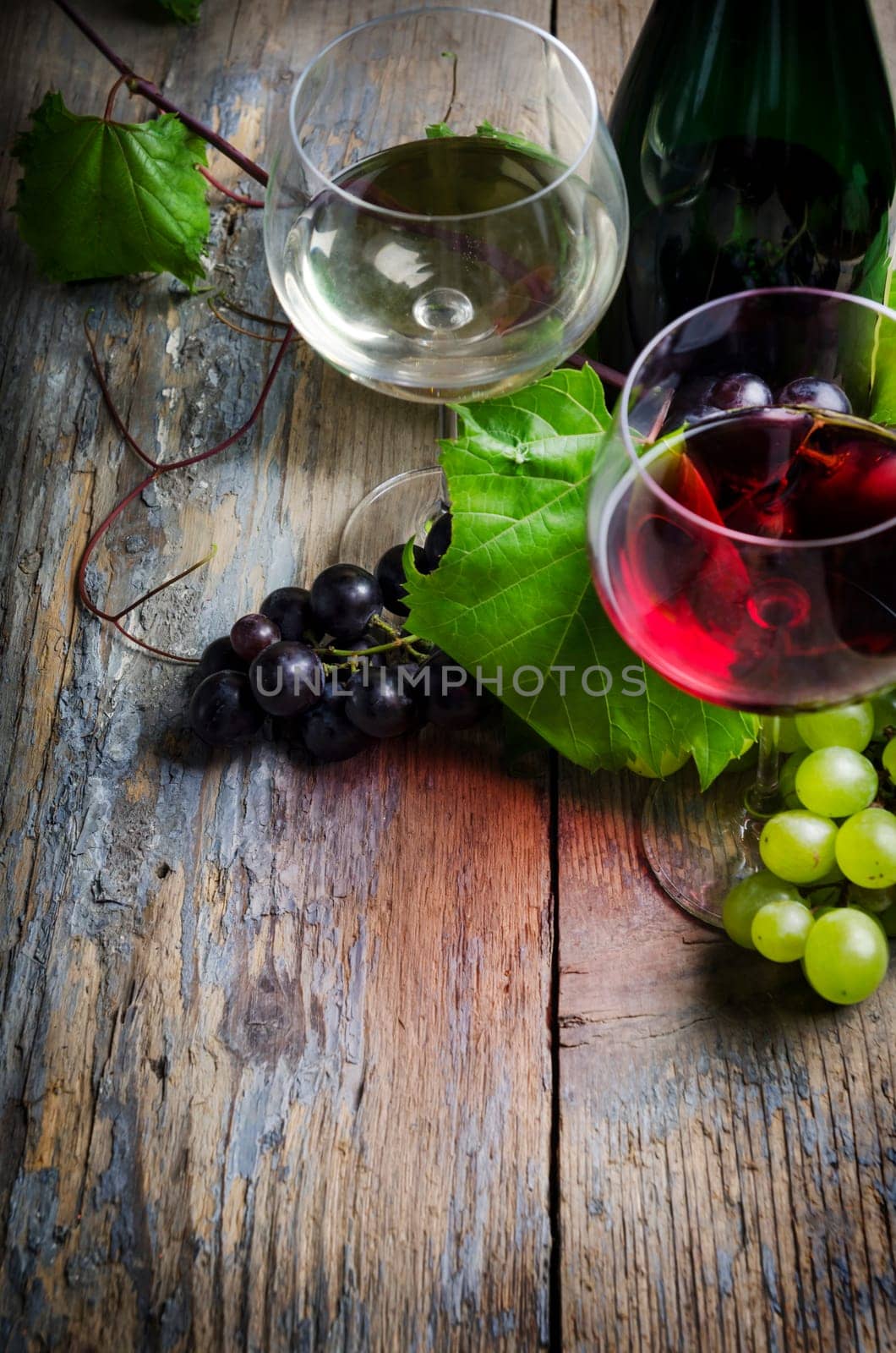 Wine glasses and grape on rustic wooden table