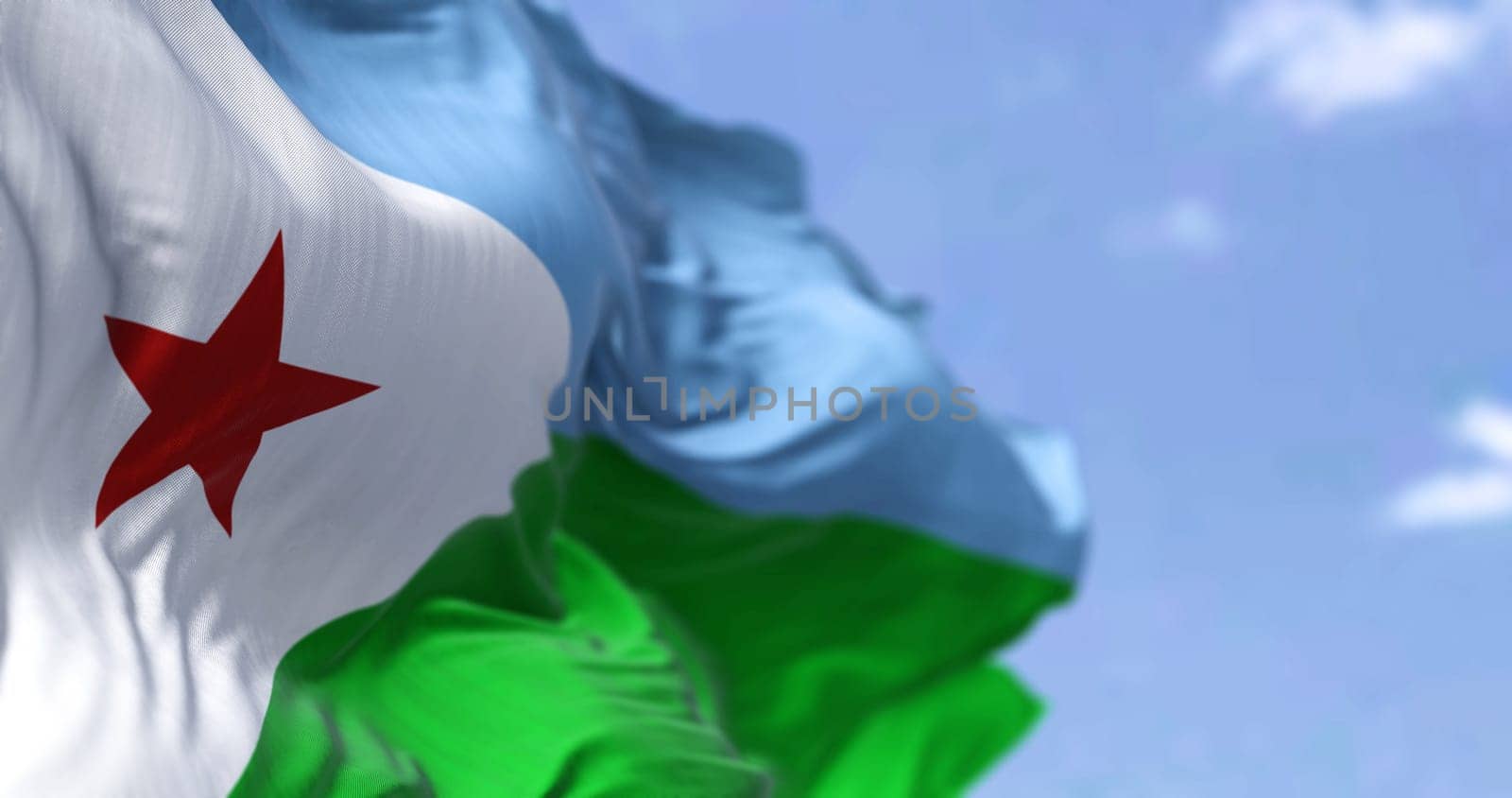 Detail of the national flag of Djibouti waving in the wind on a clear day. Djibouti is a country located in the Horn of Africa. Selective focus.