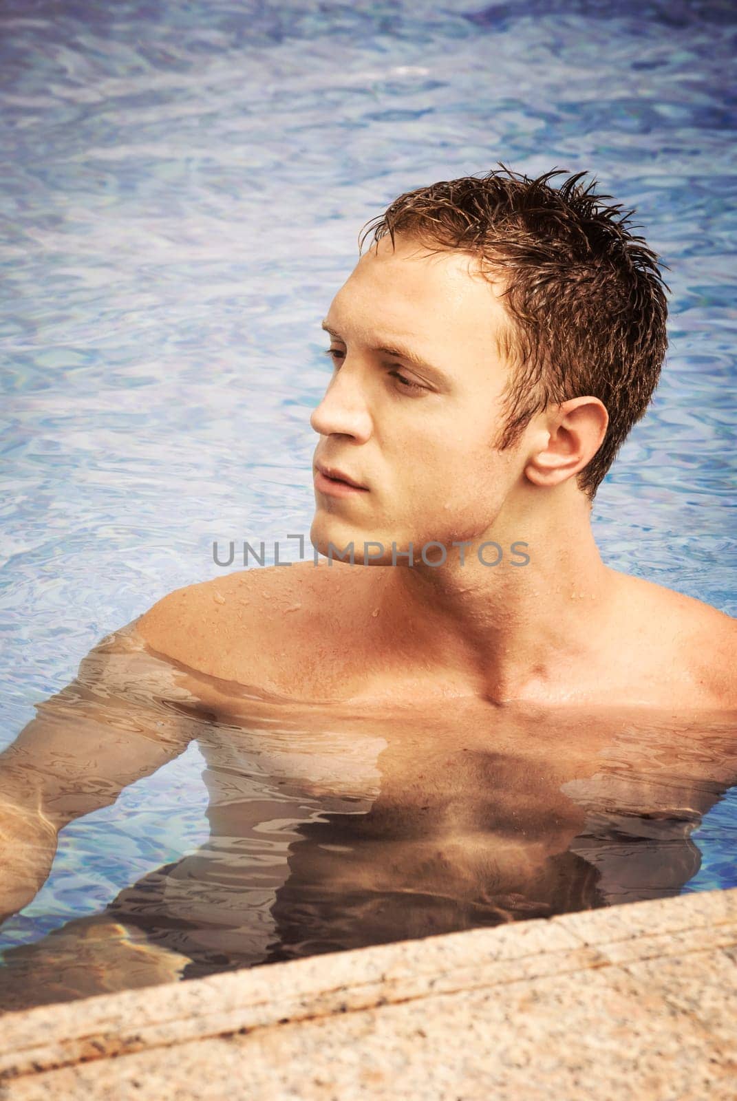 Handsome blond man swimming in the pool