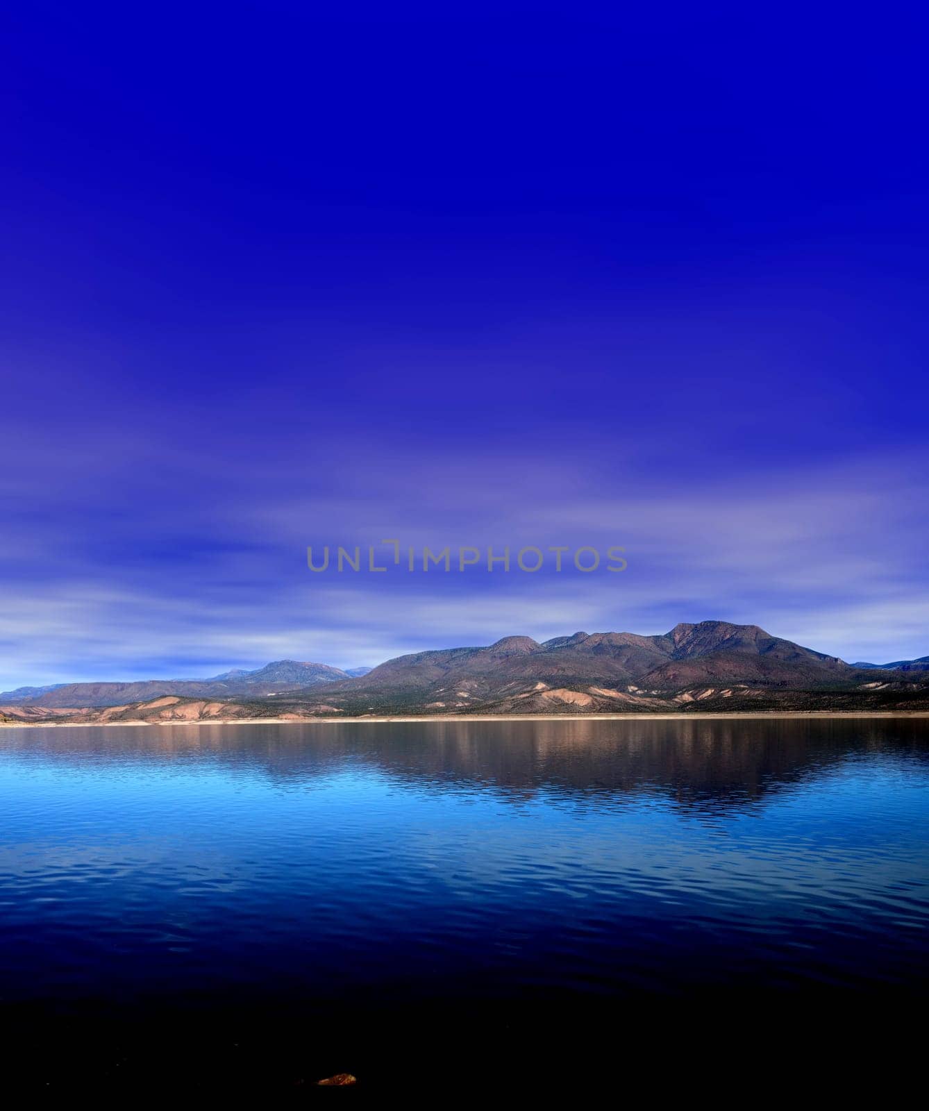 Mountain and reflections of Mountain in Roosevelt lake Central Arizona