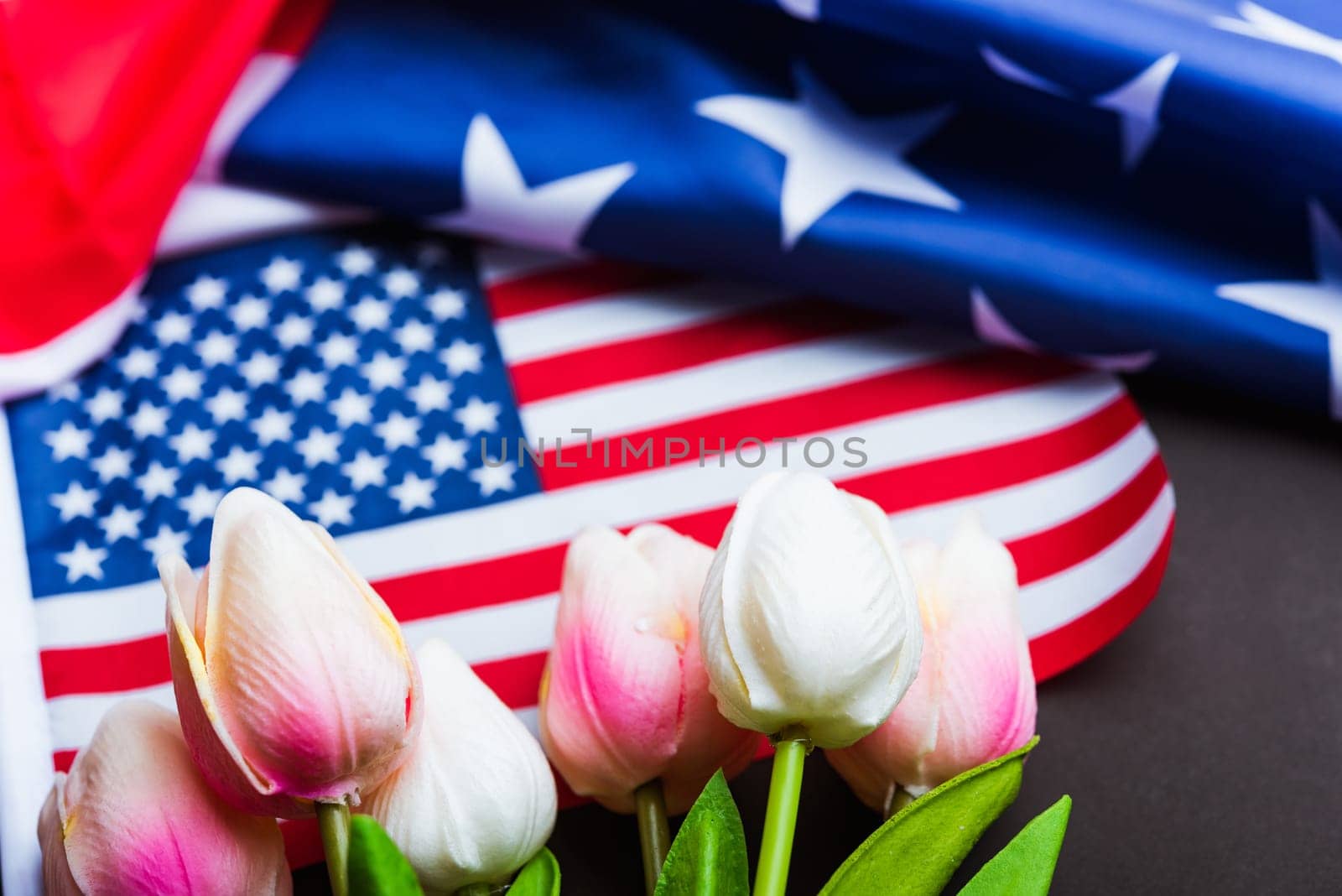 Happy Memorial Day Remember previously but now seldom called Decoration Day, American flag and a Tulip flower on a black background and copy space, a federal holiday in the United States