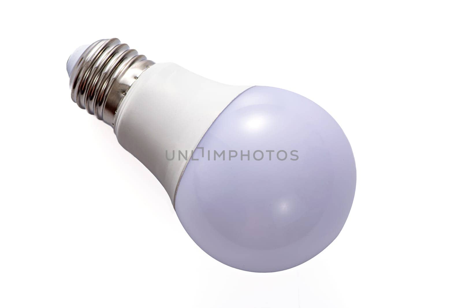 A white LED lamp with an E27 base lies on a white insulated background. High quality photo
